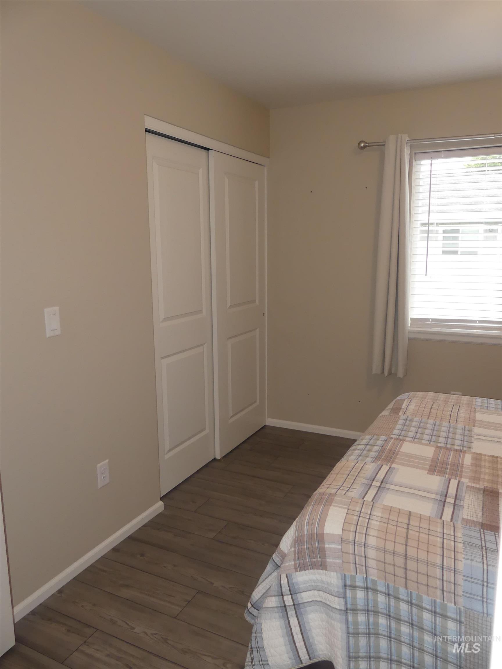 Bedroom featuring dark wood finished floors and a closet