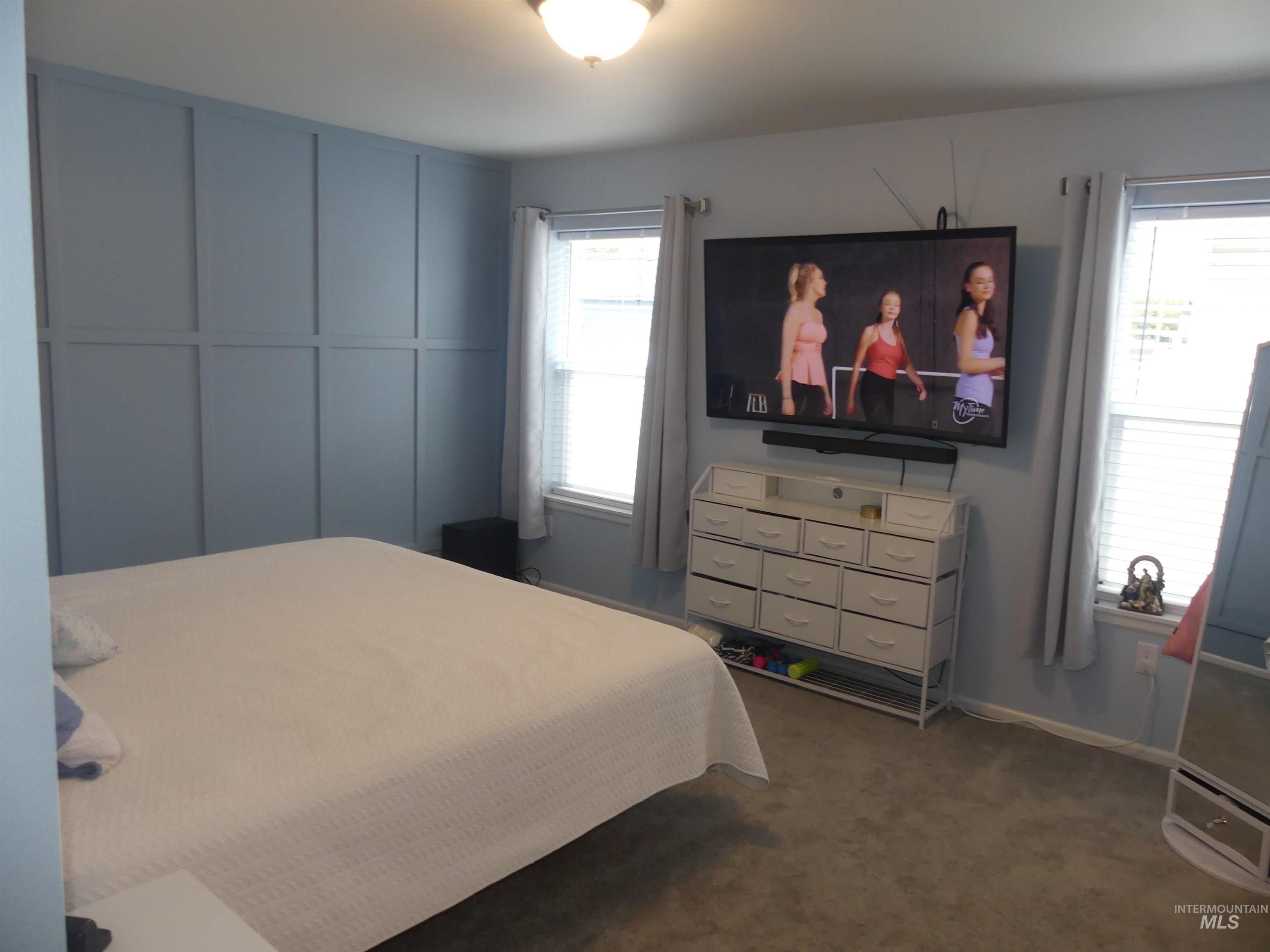 Bedroom featuring dark carpet and baseboards