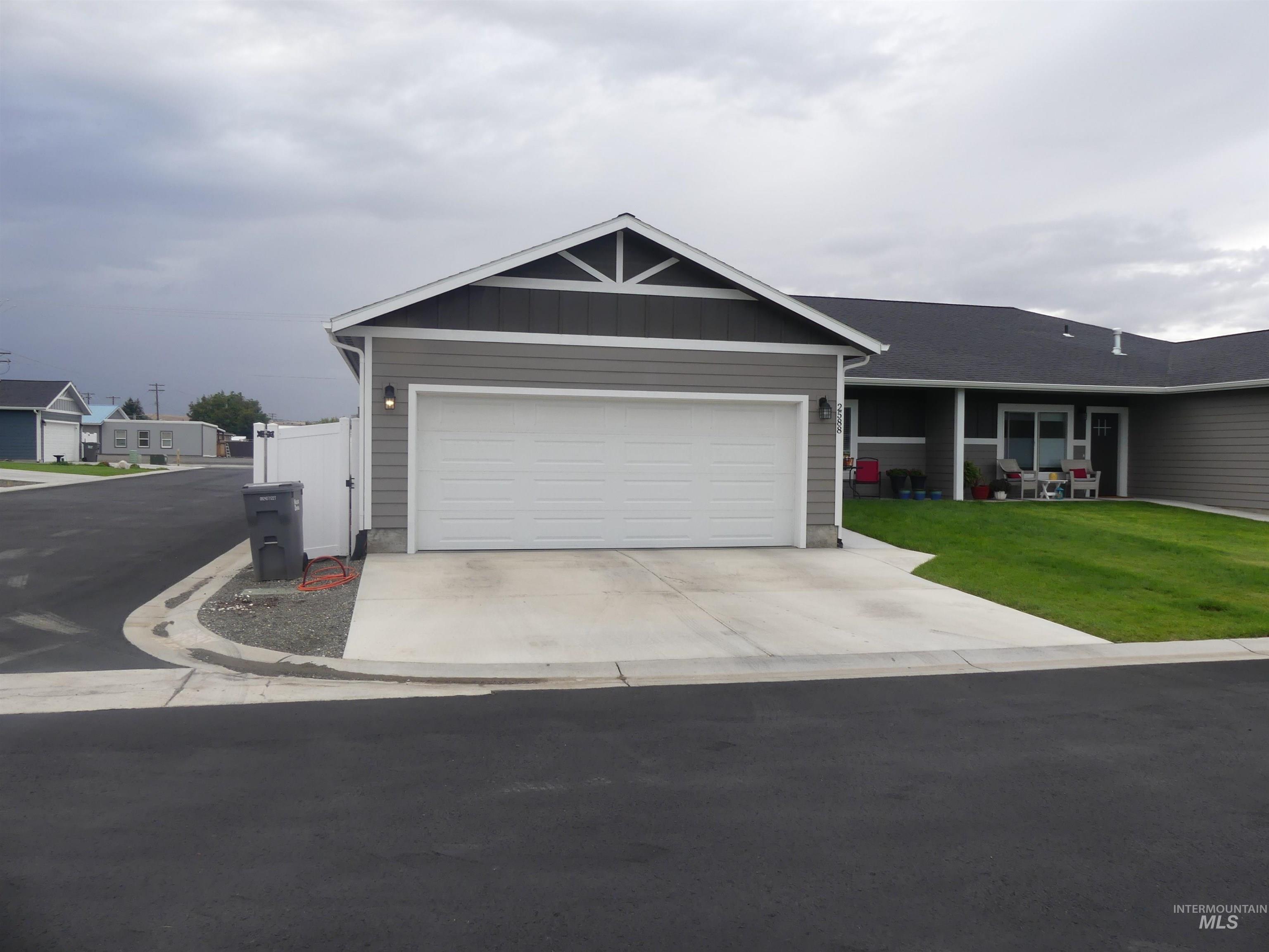 Ranch-style house with board and batten siding, concrete driveway, and a garage