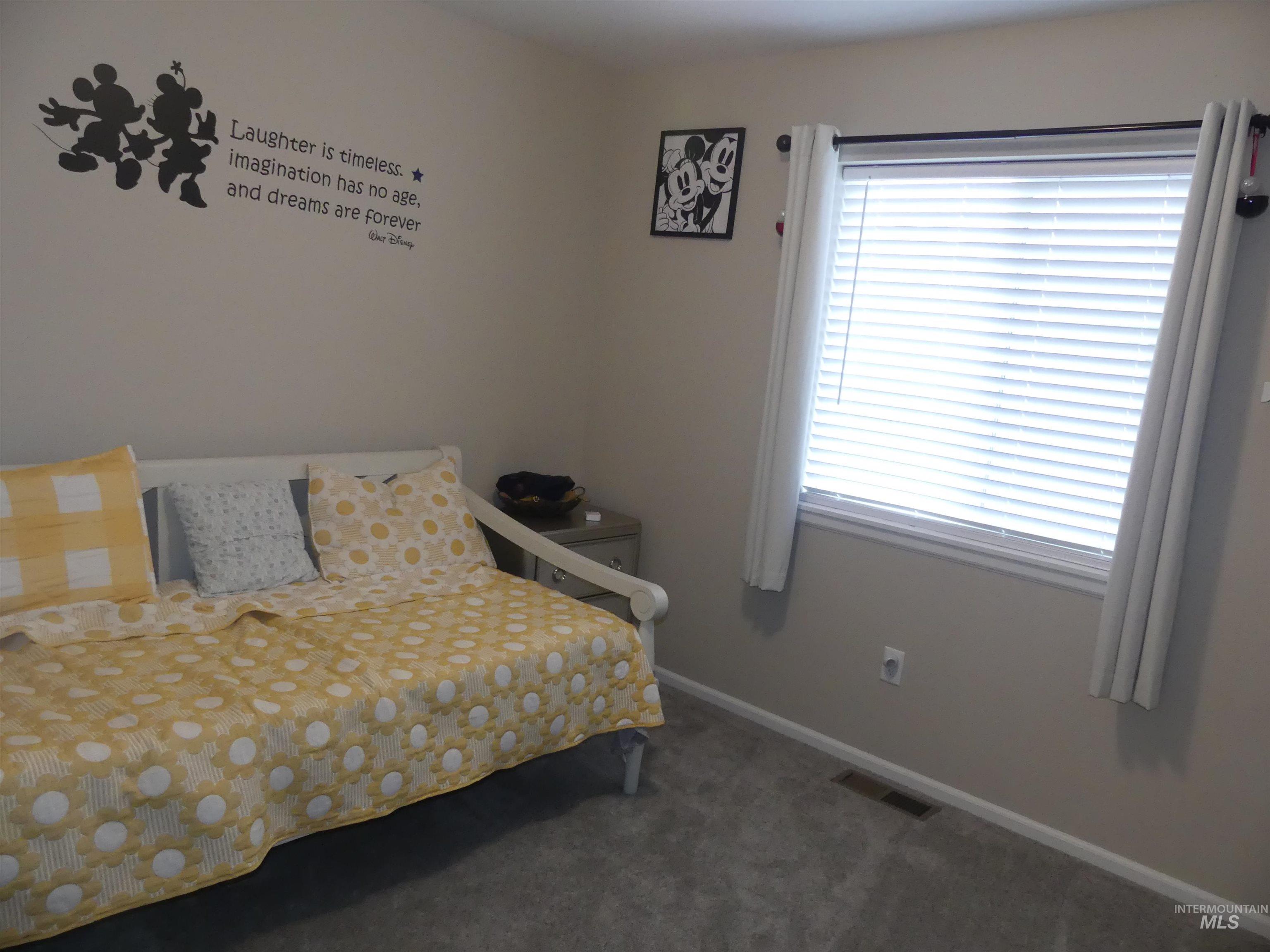 Bedroom featuring carpet and baseboards
