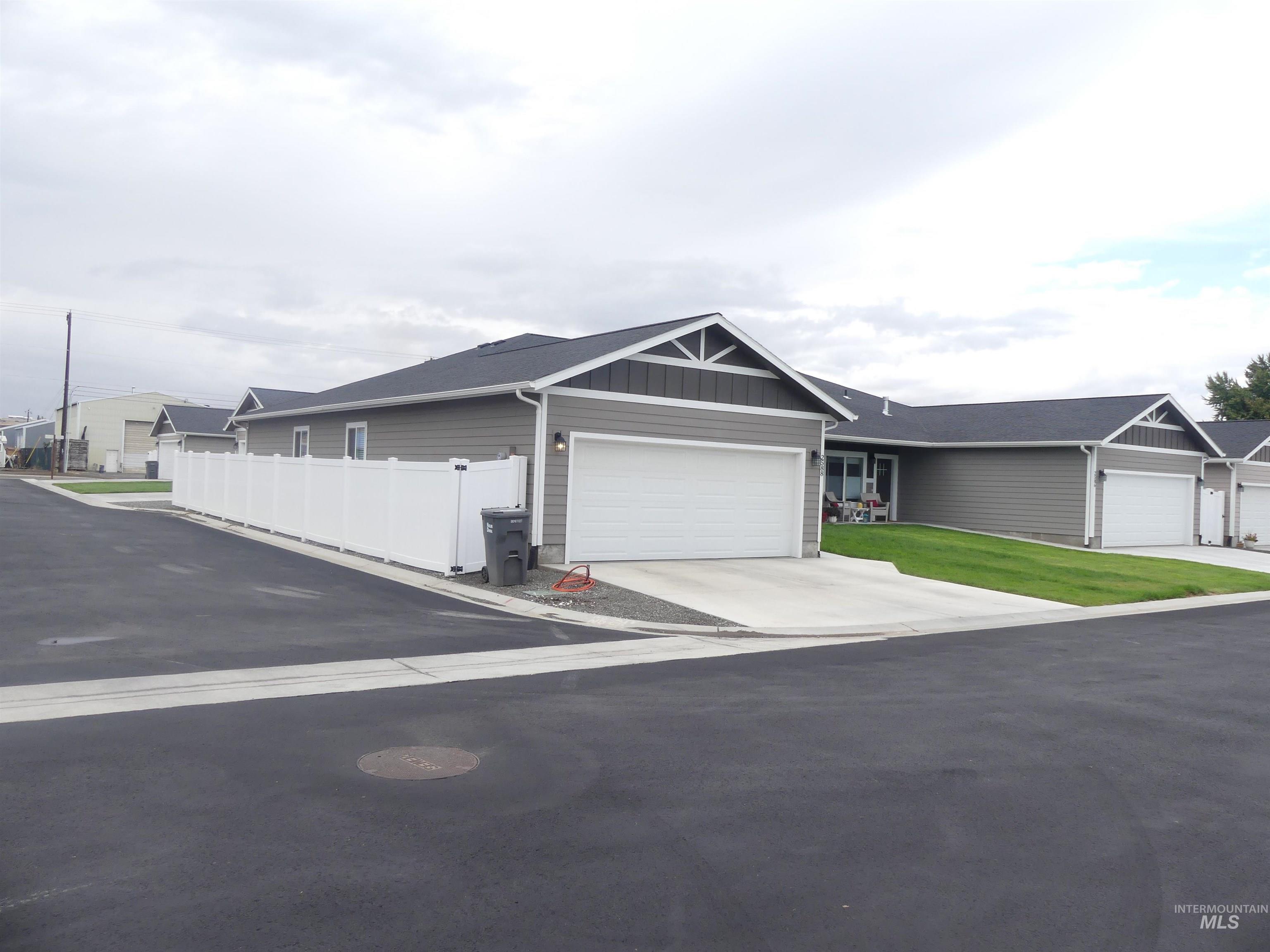 Single story home with board and batten siding, concrete driveway, and a garage