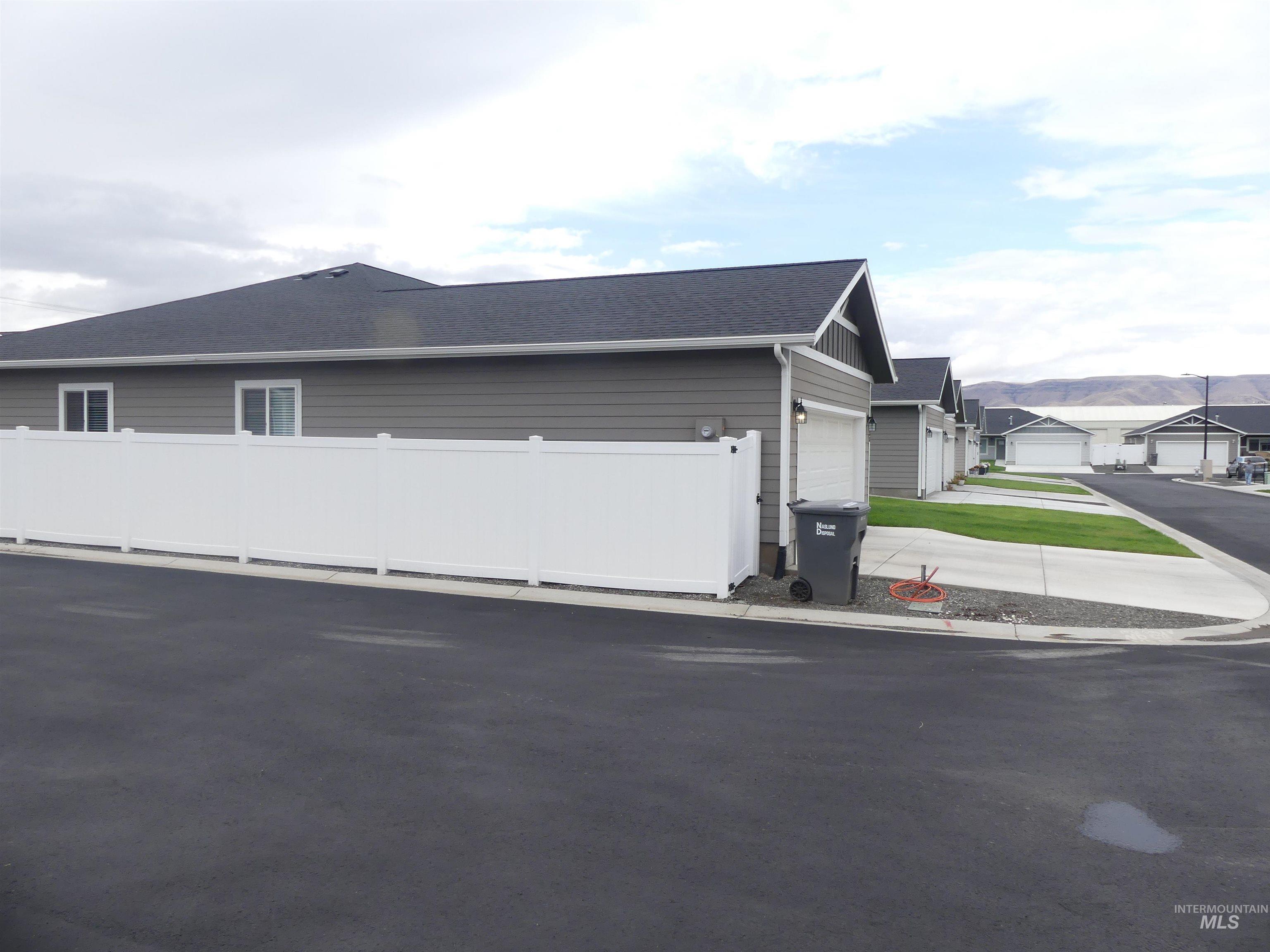 View of home's exterior featuring a shingled roof and a residential view