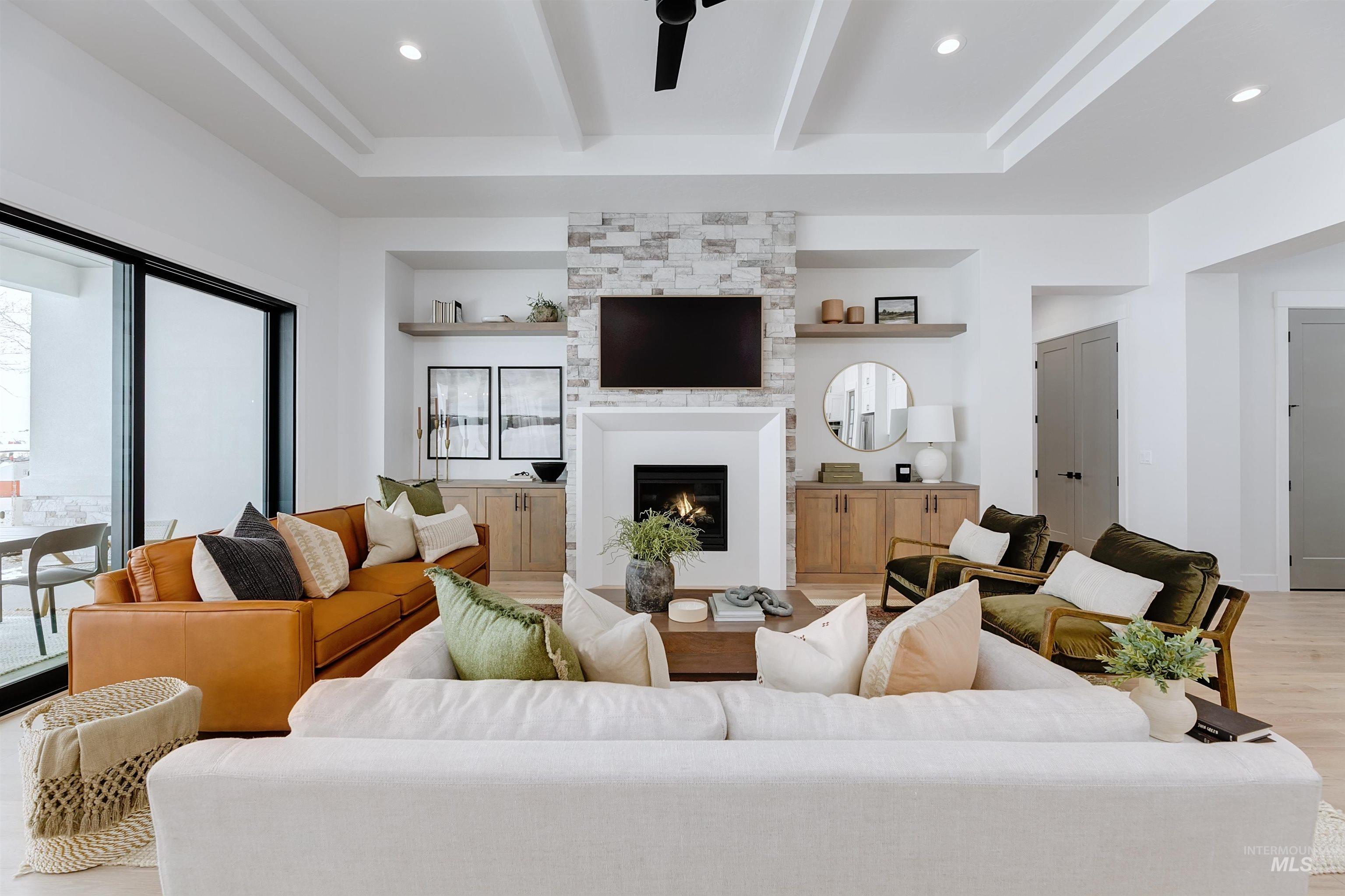 Living area with beam ceiling, a fireplace, light wood-type flooring, recessed lighting, and ceiling fan