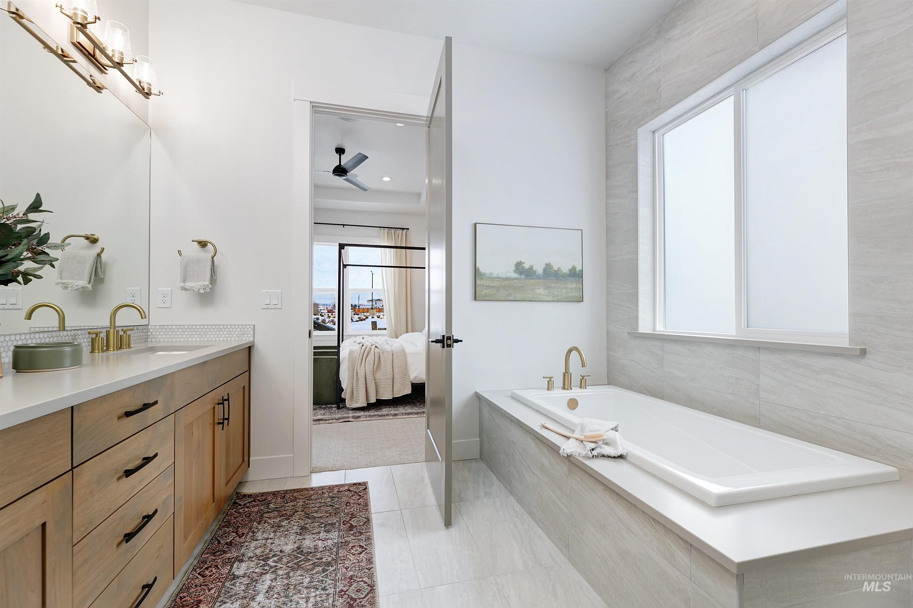 Bathroom featuring vanity, a bath, healthy amount of natural light, and ensuite bathroom