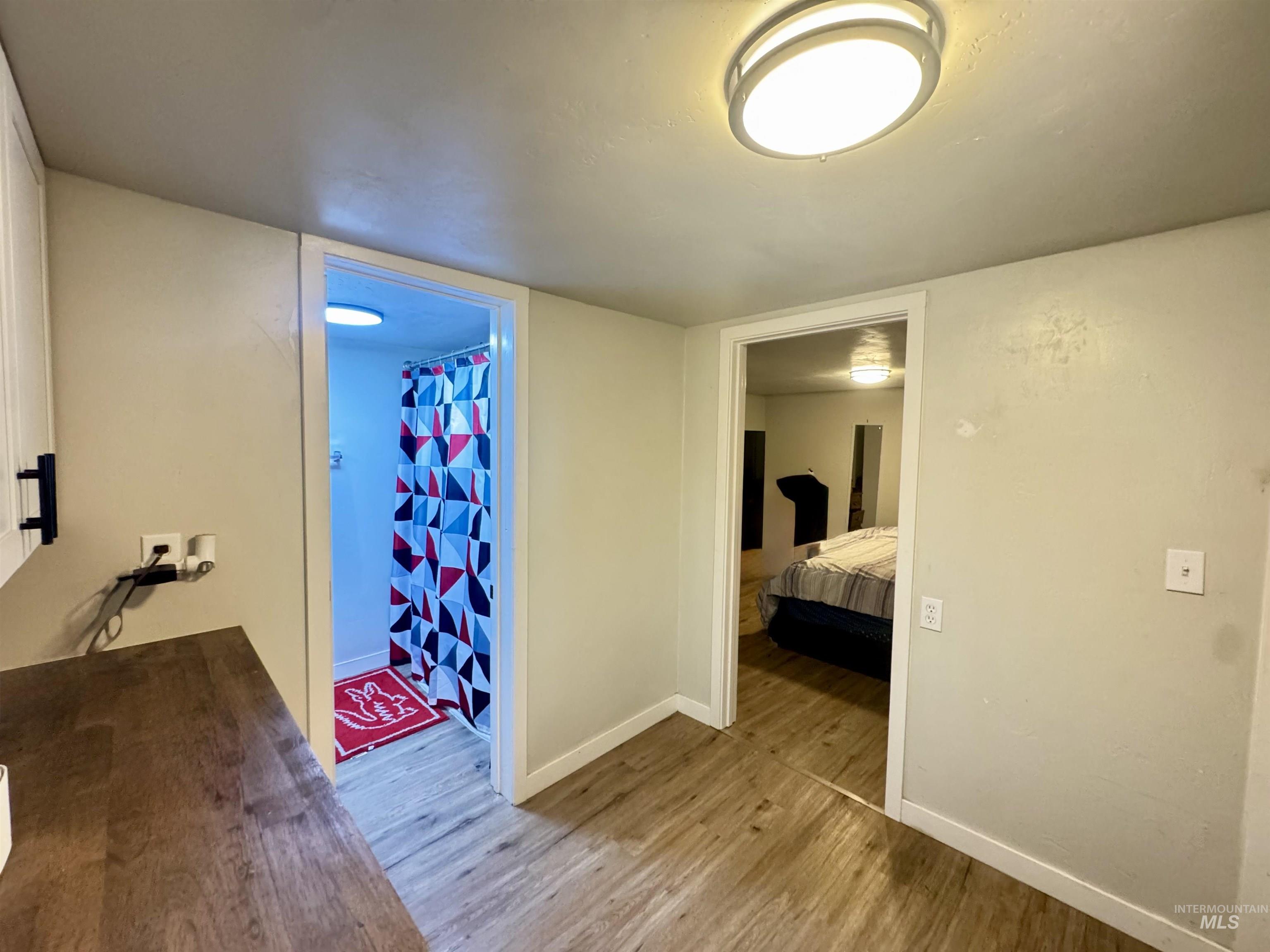 Hall with light wood-style flooring and baseboards