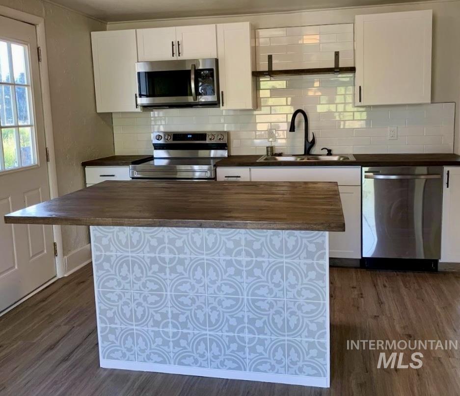Kitchen with white cabinetry, tasteful backsplash, and appliances with stainless steel finishes