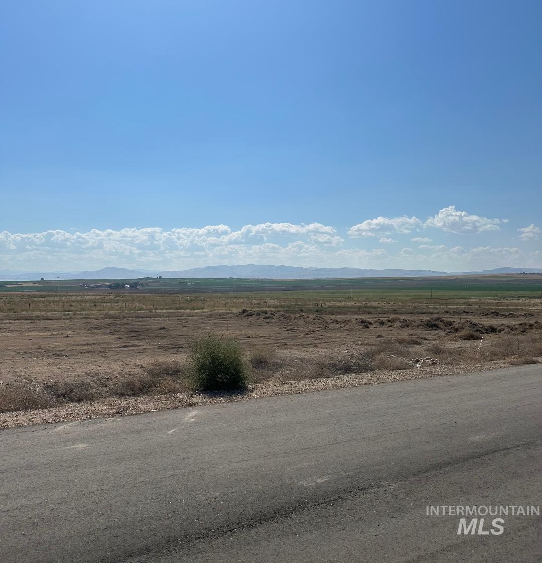 View of asphalt road with a view of rural / pastoral area and a mountain view