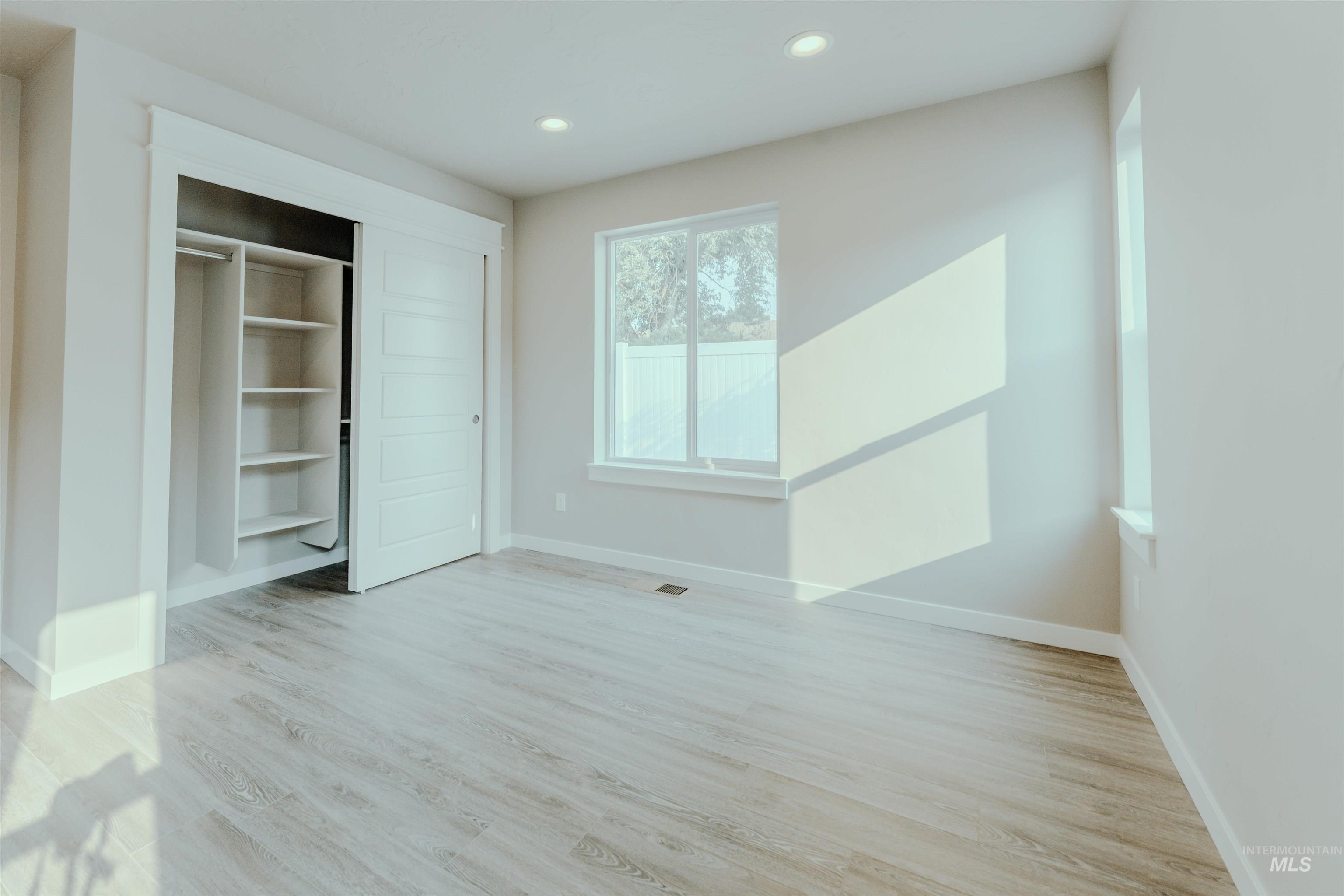 Unfurnished bedroom with light wood-type flooring, a closet, and recessed lighting