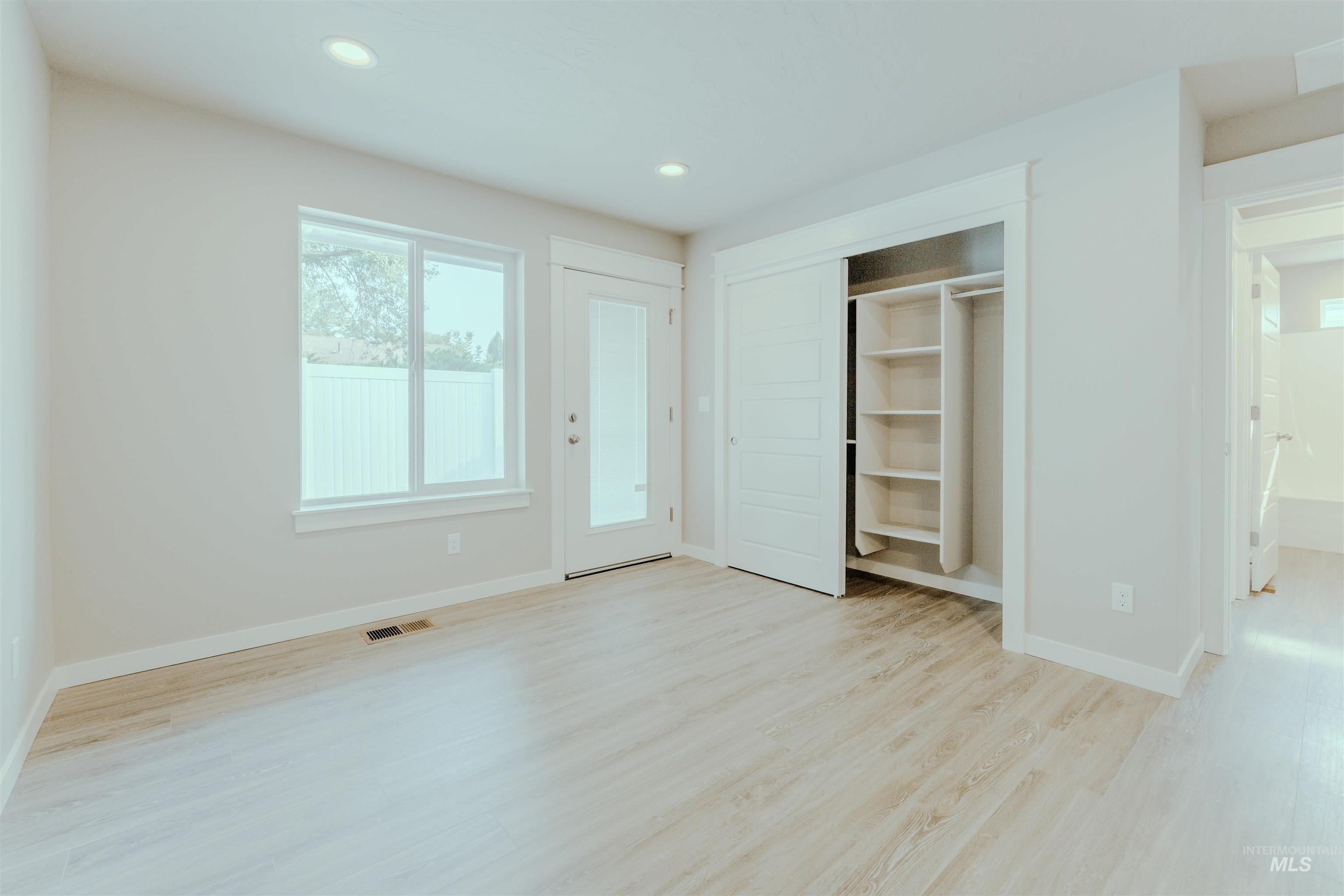 Unfurnished bedroom featuring light wood-type flooring, recessed lighting, and a closet