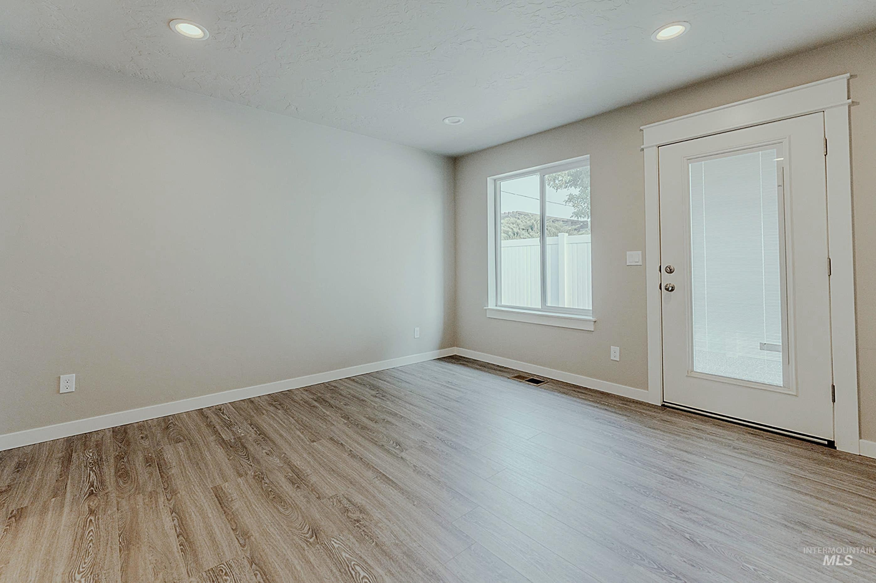 Spare room featuring light wood-style floors, recessed lighting, and a textured ceiling