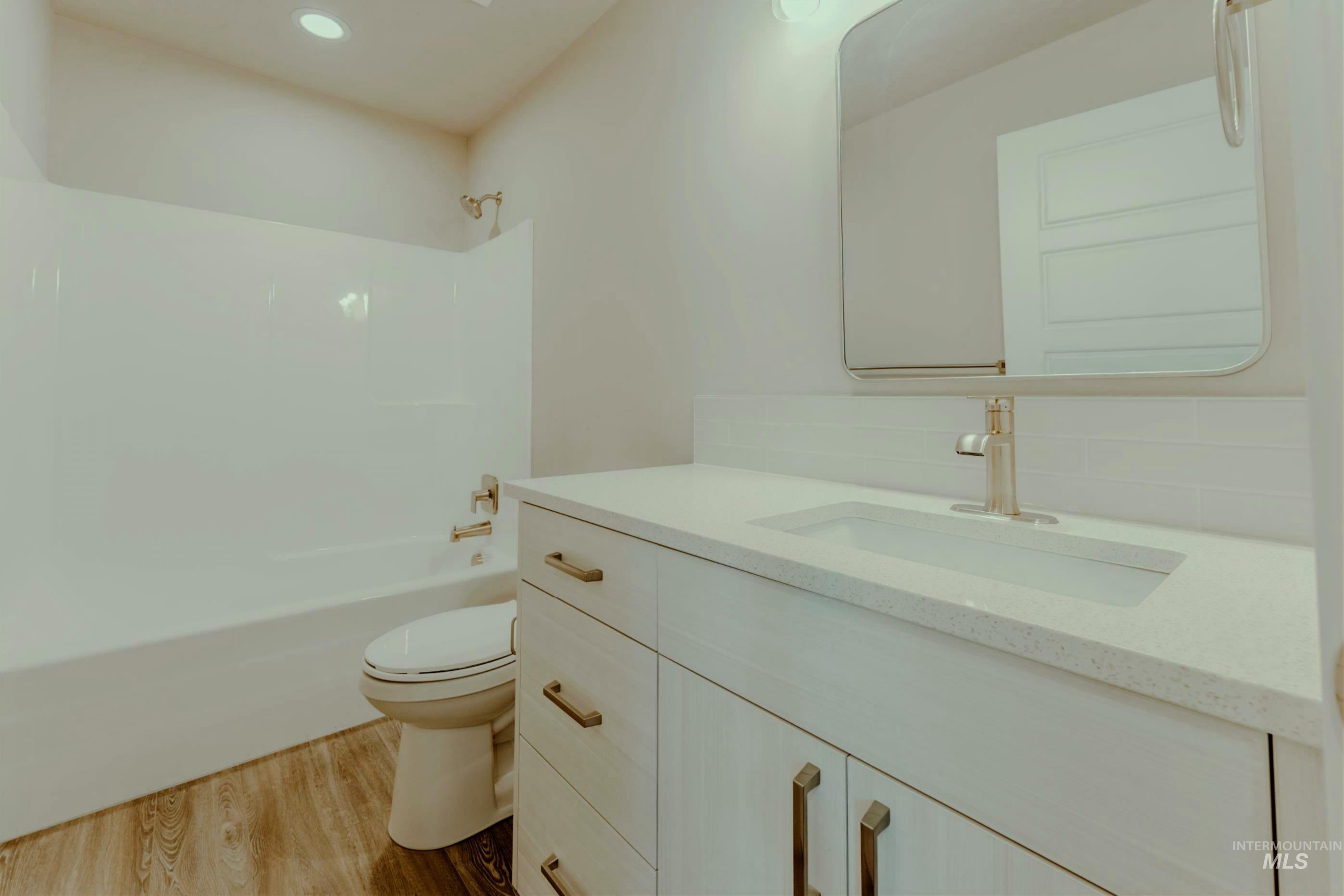 Full bathroom featuring light wood-style floors, bathing tub / shower combination, vanity, and recessed lighting