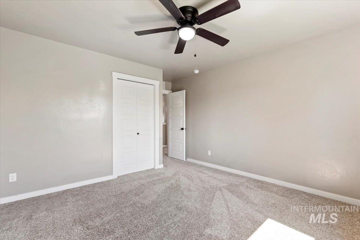 Unfurnished bedroom featuring carpet, a closet, and ceiling fan