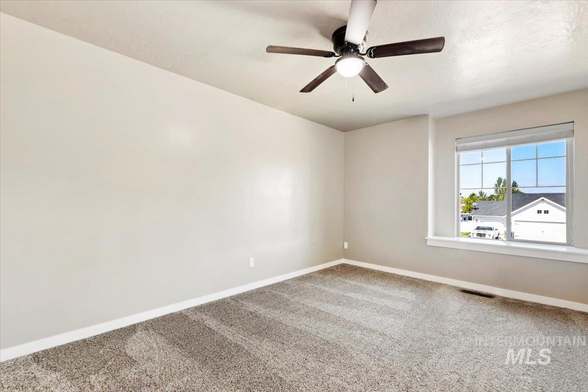 Spare room featuring carpet flooring and a ceiling fan