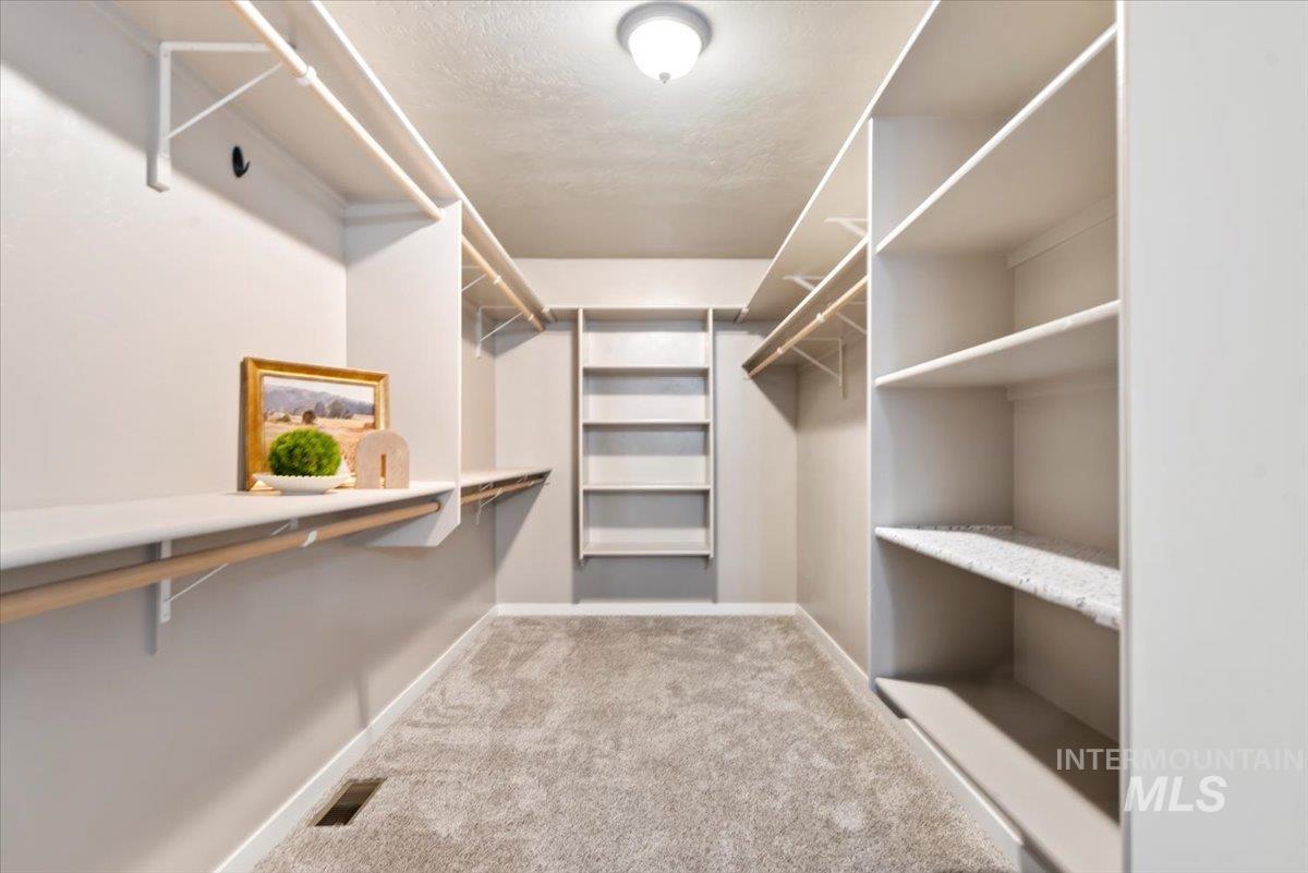 Spacious closet with light colored carpet