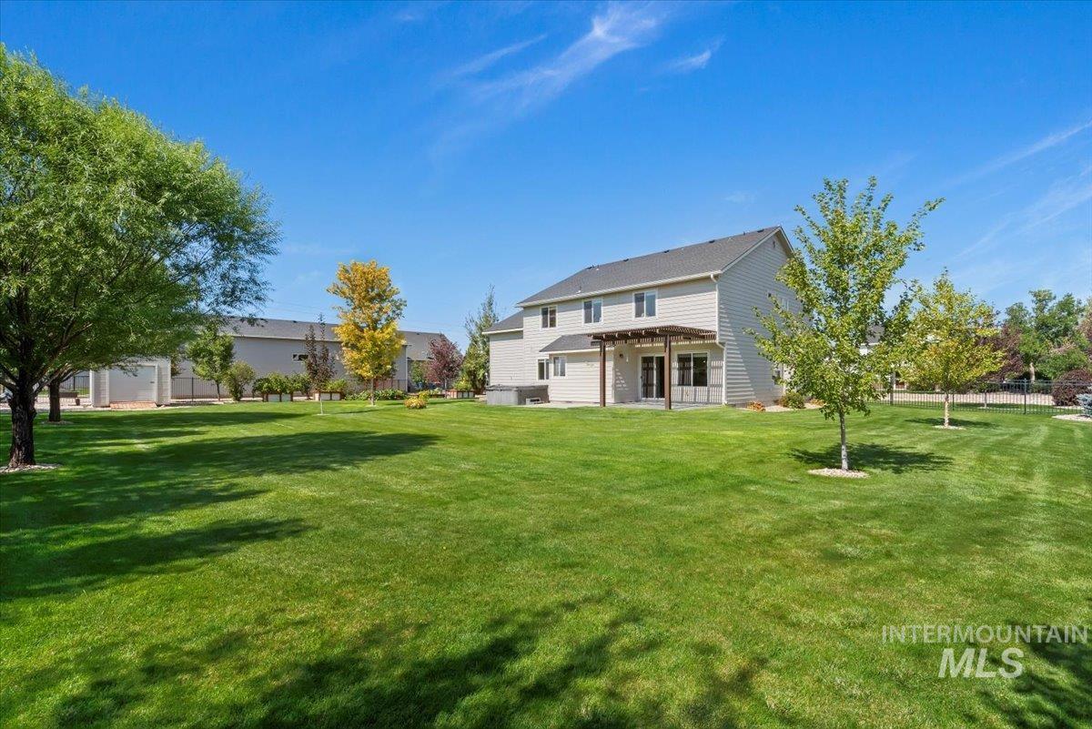 Rear view of property with a lawn and a patio area