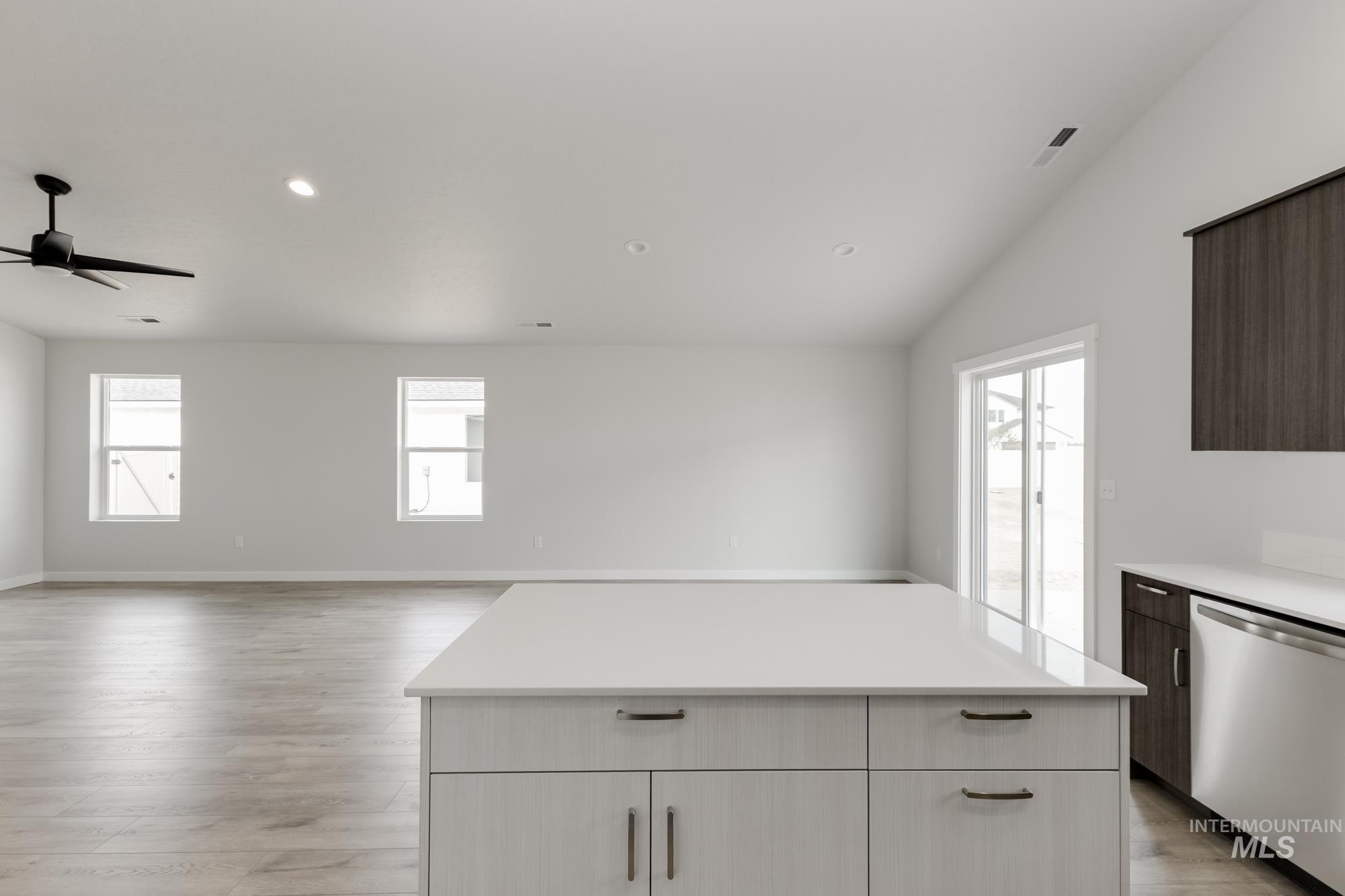 Kitchen featuring stainless steel dishwasher, white cabinets, recessed lighting, light wood-style flooring, and ceiling fan
