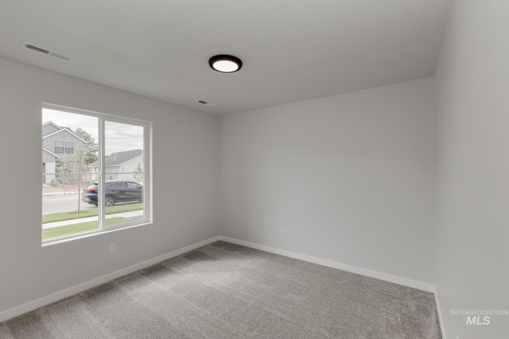 Unfurnished room featuring light colored carpet and baseboards
