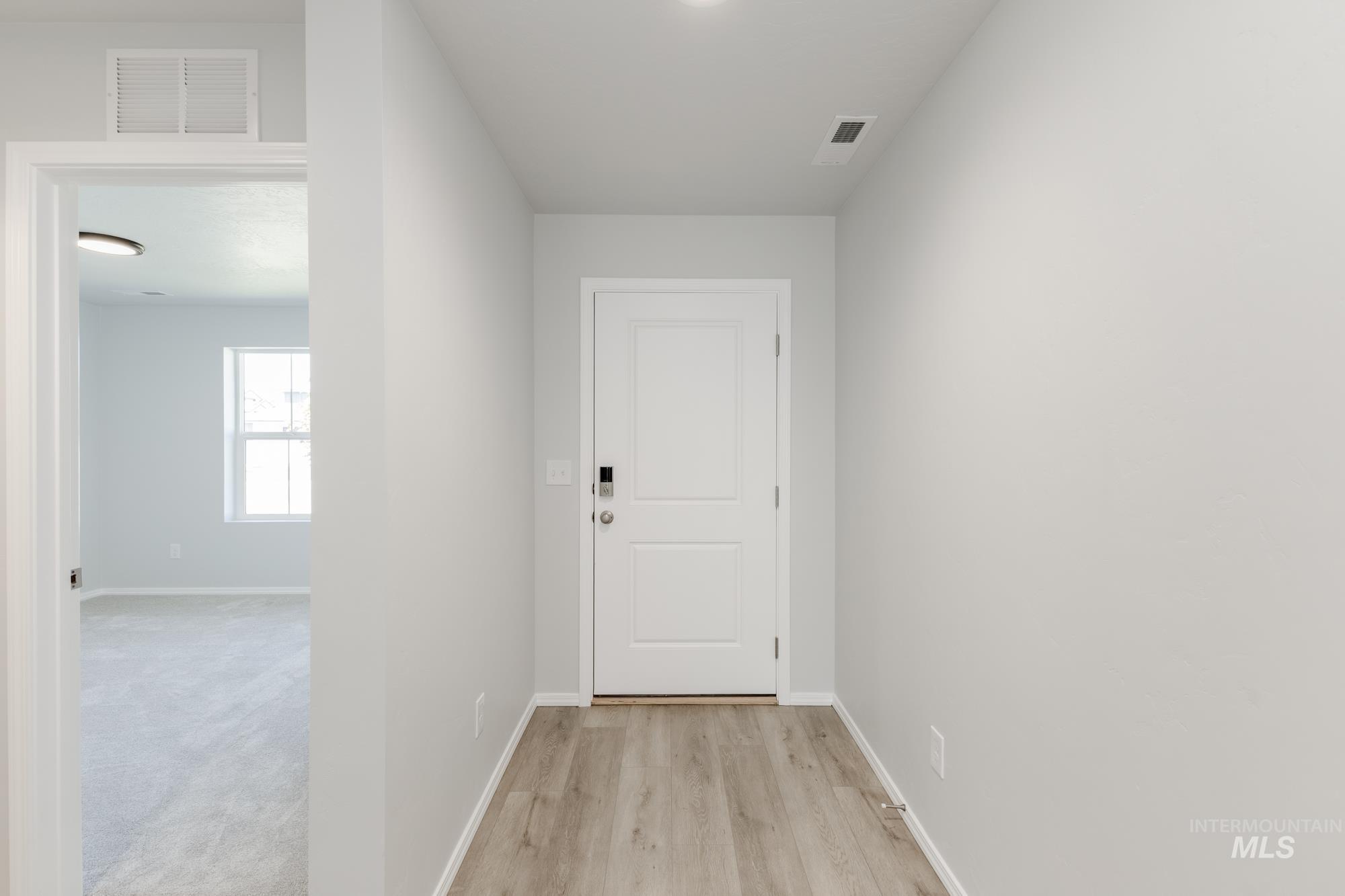 Hallway with baseboards and light wood finished floors