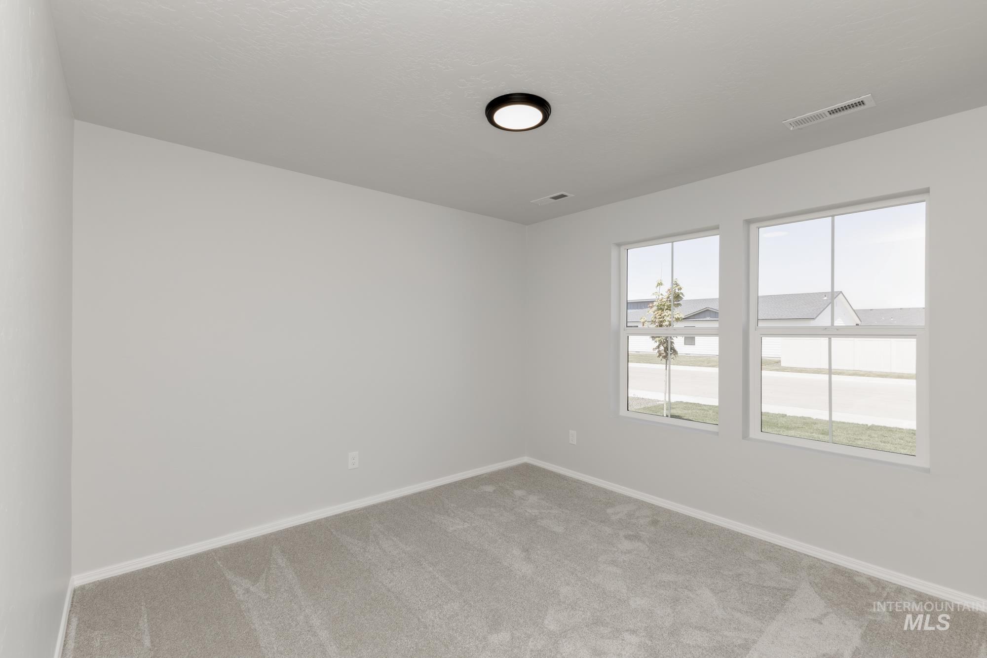 Empty room featuring light carpet and baseboards