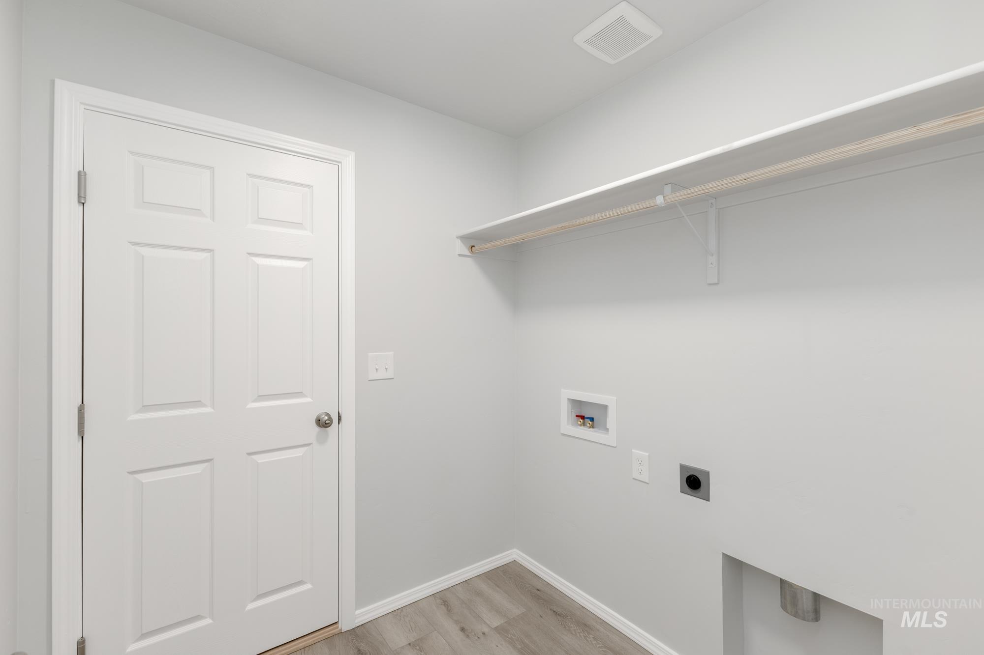 Washroom featuring electric dryer hookup, washer hookup, and light wood-type flooring