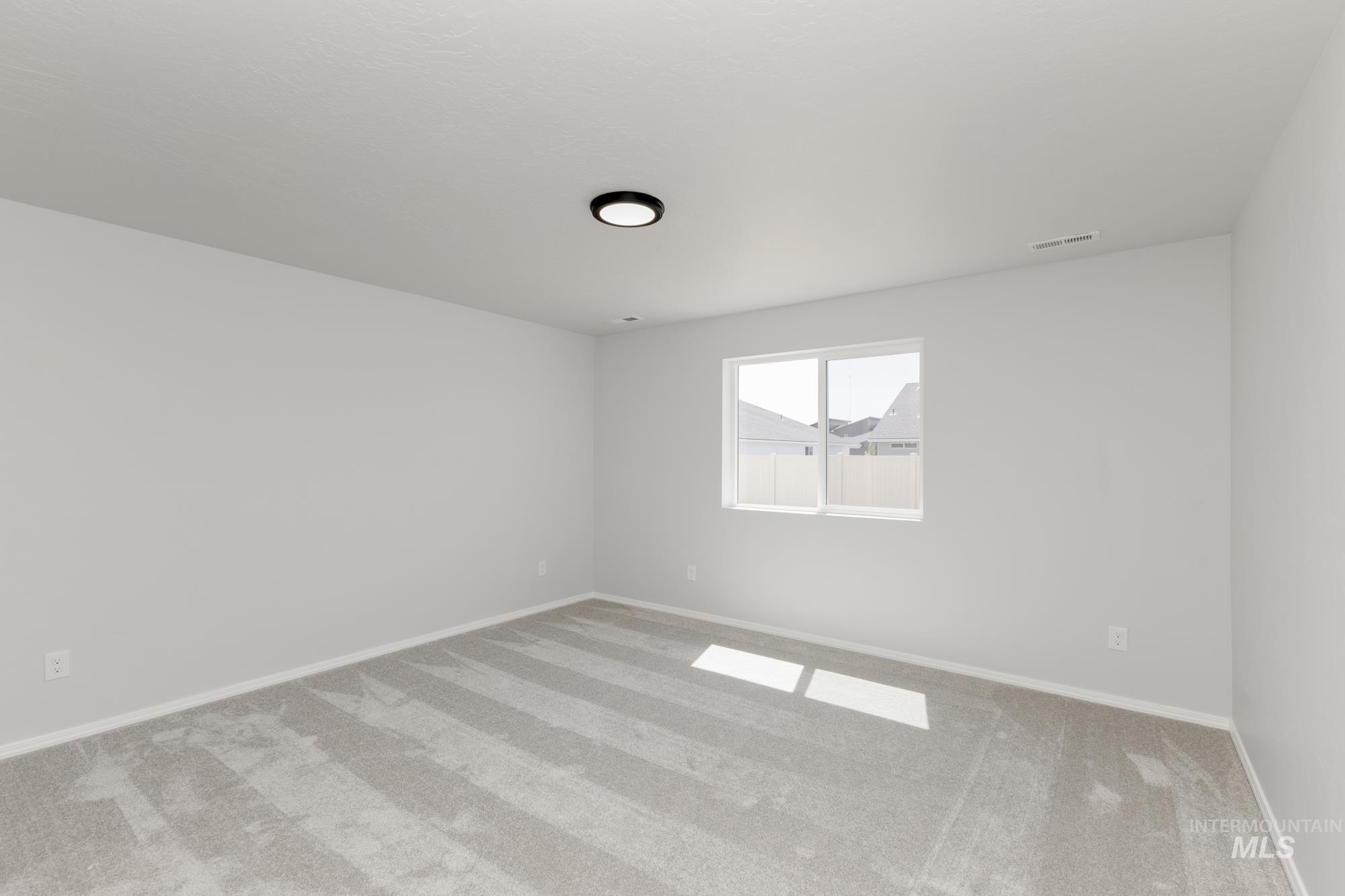 Spare room featuring light carpet