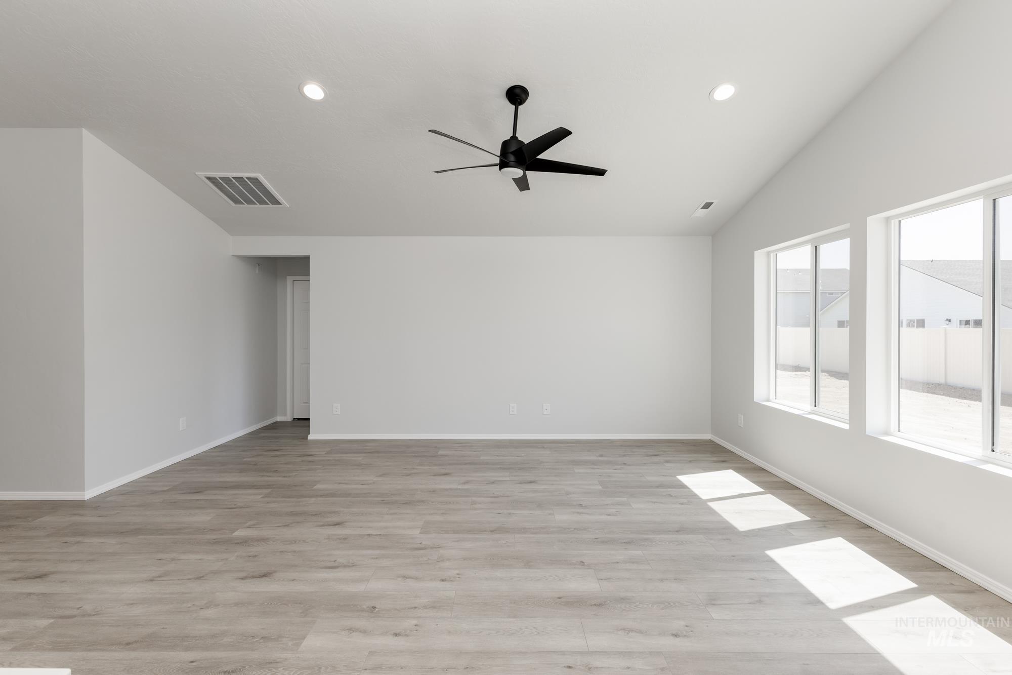 Spare room featuring a ceiling fan, light wood-type flooring, lofted ceiling, and recessed lighting