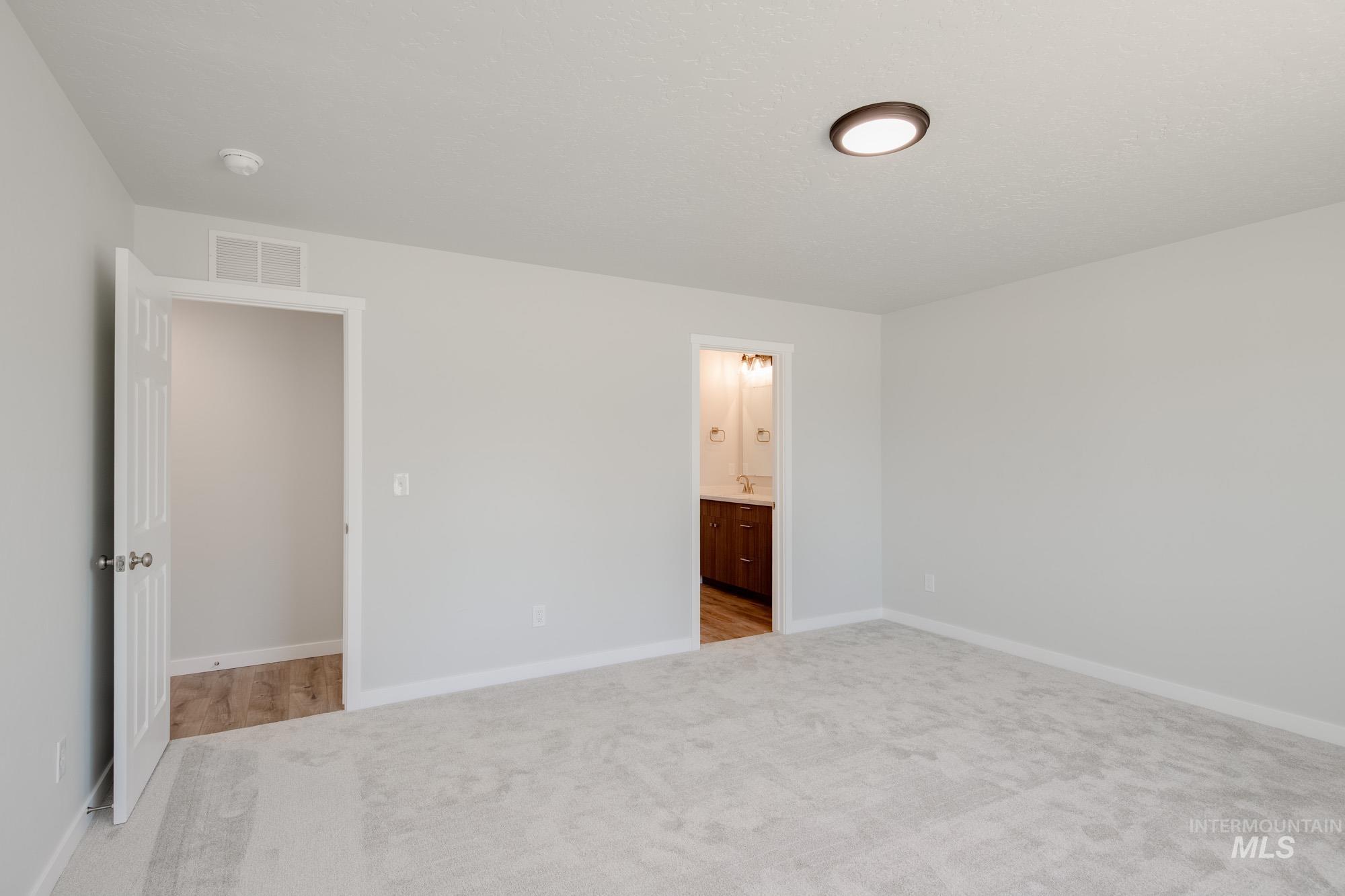 Unfurnished bedroom featuring carpet floors and ensuite bath