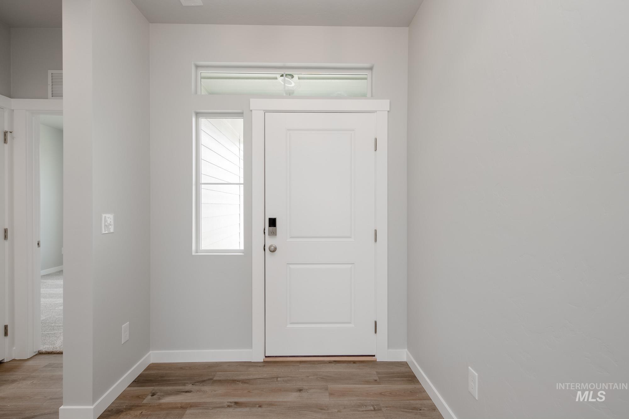 Entryway with light wood-type flooring and baseboards