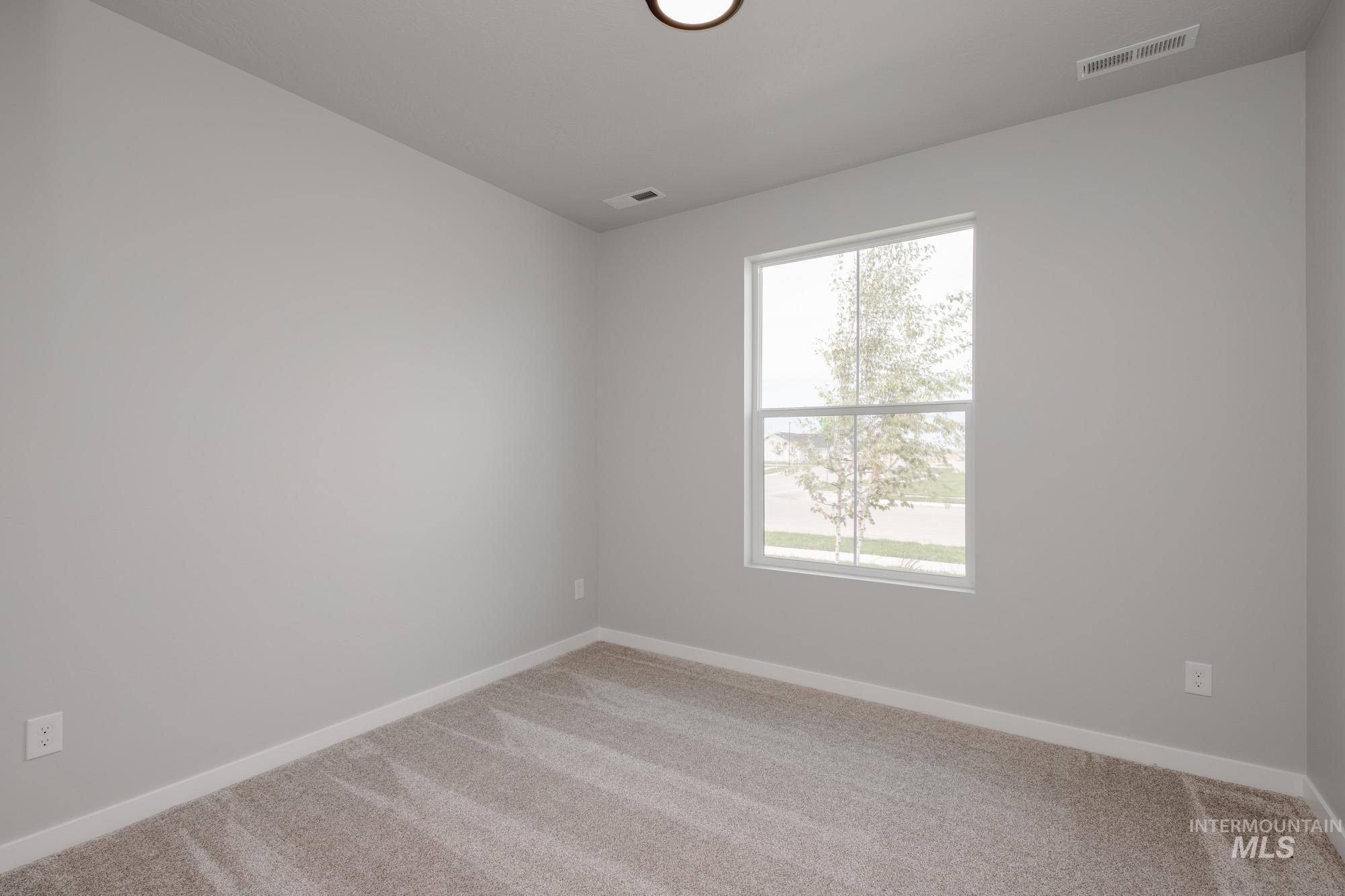 Spare room featuring carpet floors and baseboards