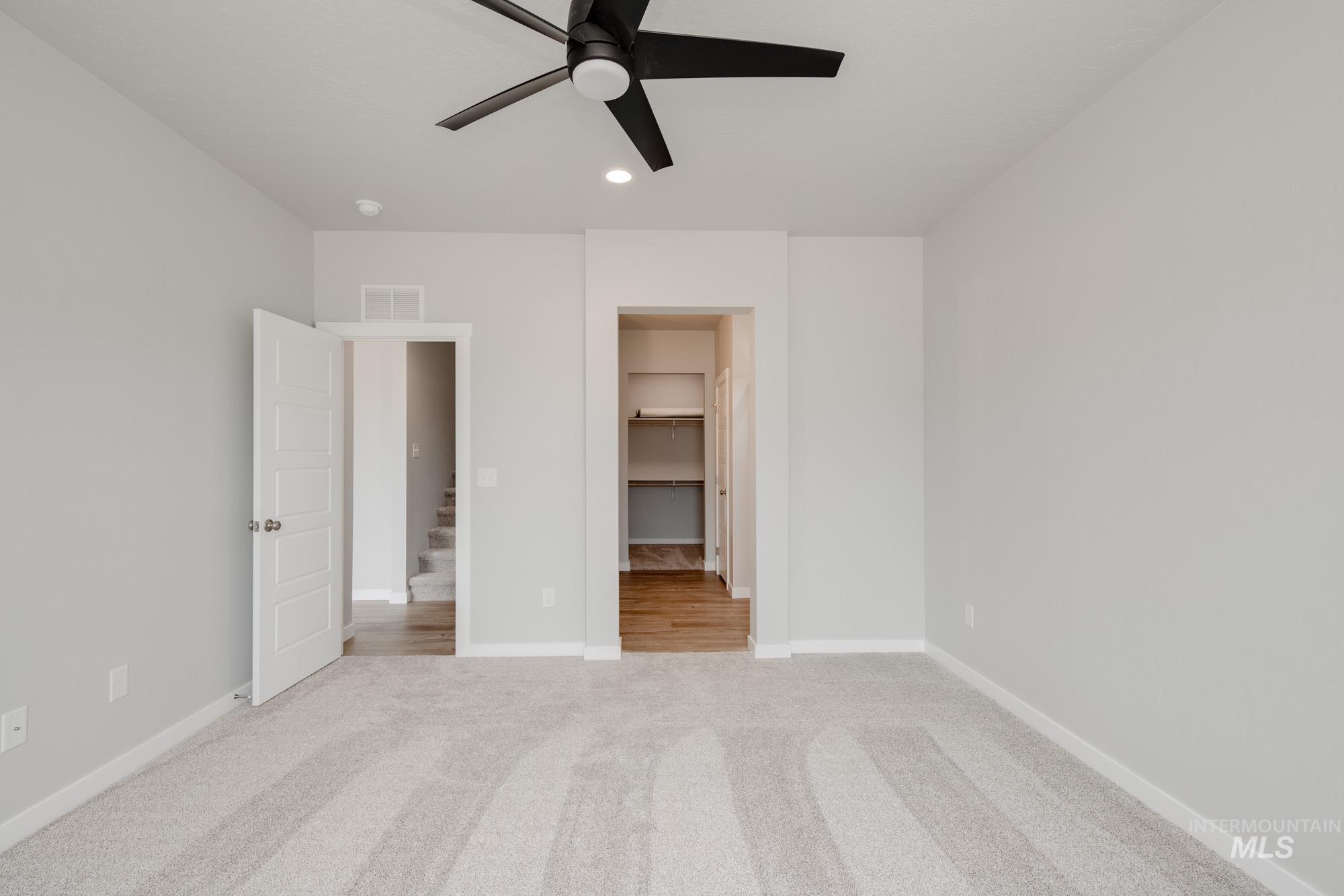 Unfurnished bedroom with carpet flooring, recessed lighting, a walk in closet, and ceiling fan