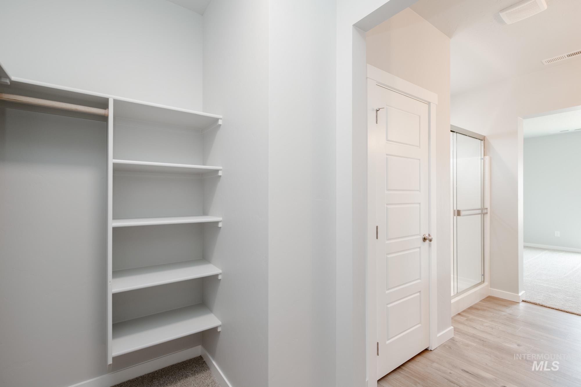 Walk in closet with wood finished floors