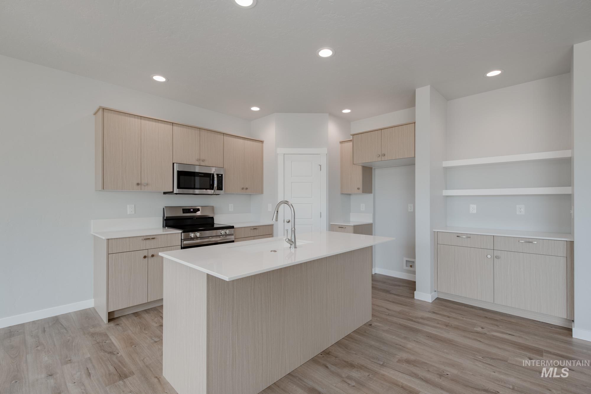 Kitchen with appliances with stainless steel finishes, light wood-style floors, light countertops, recessed lighting, and light brown cabinetry