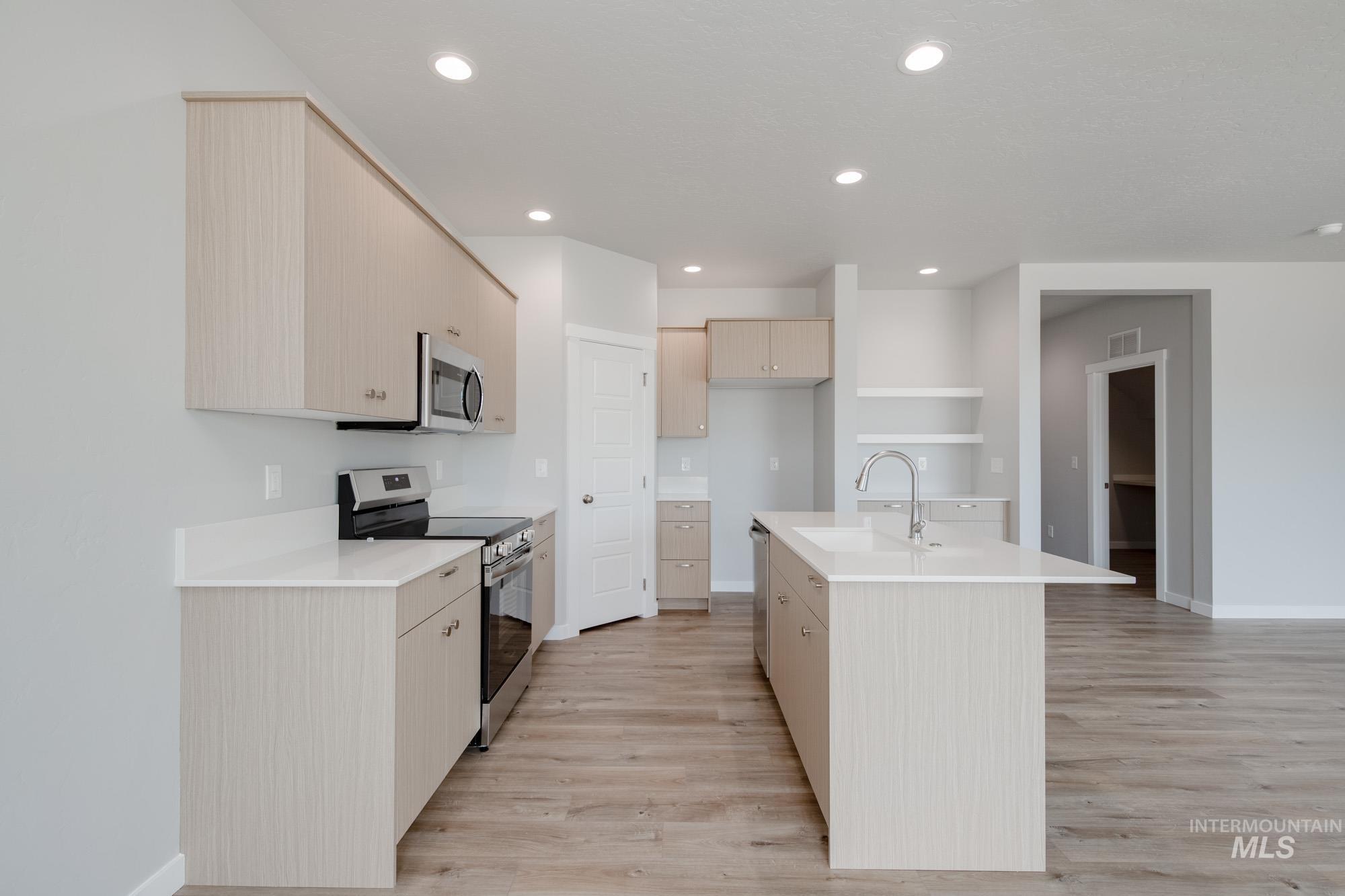 Kitchen featuring stainless steel appliances, light wood-style floors, light countertops, and recessed lighting