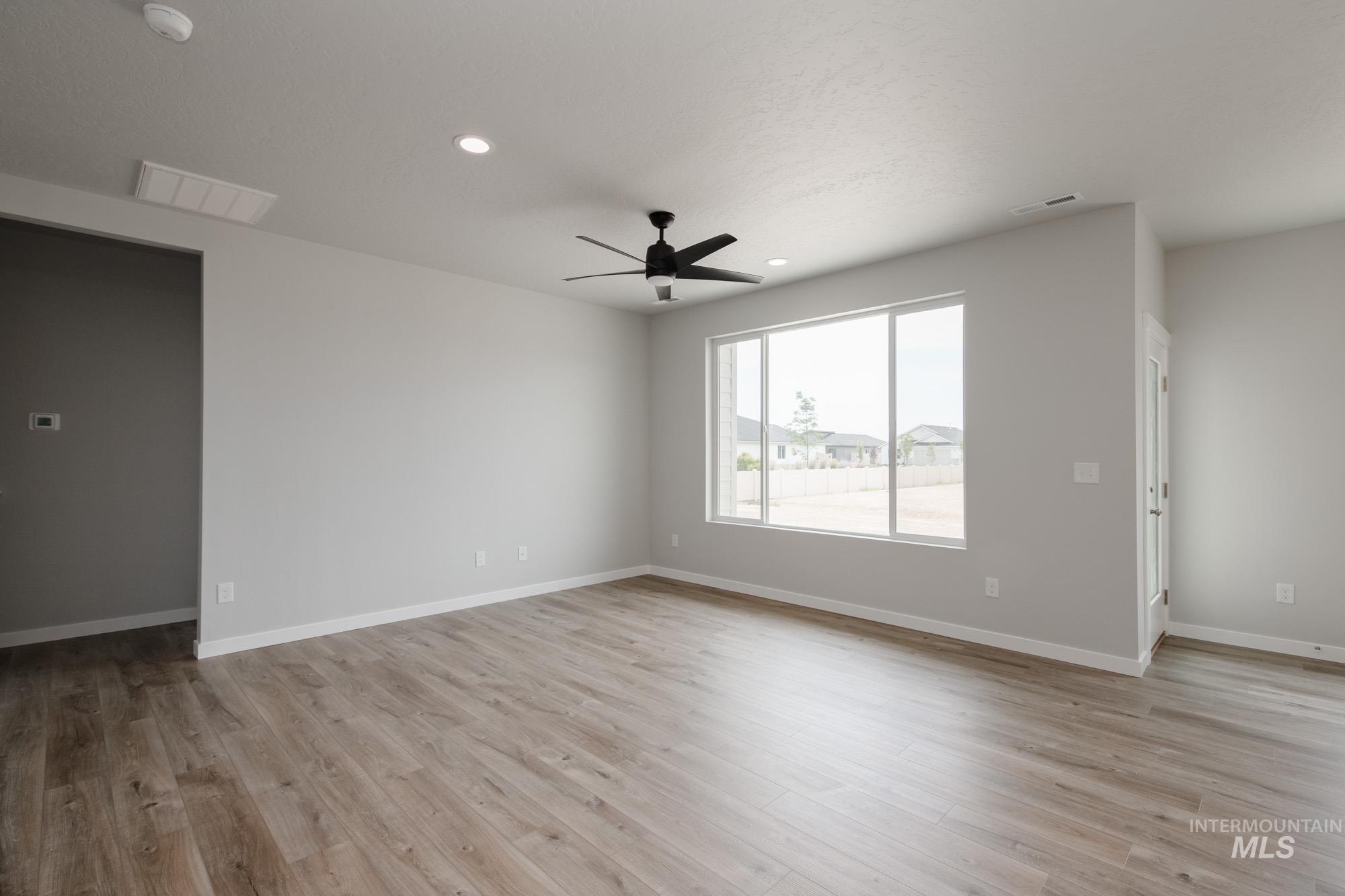 Empty room featuring light wood-style flooring, a ceiling fan, and recessed lighting
