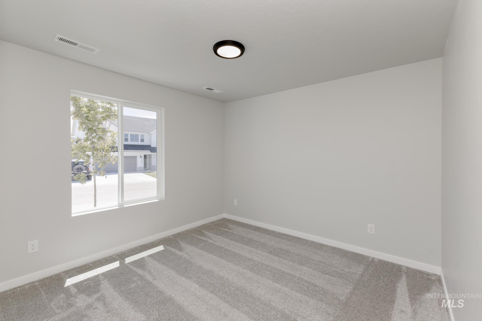 Empty room featuring light colored carpet