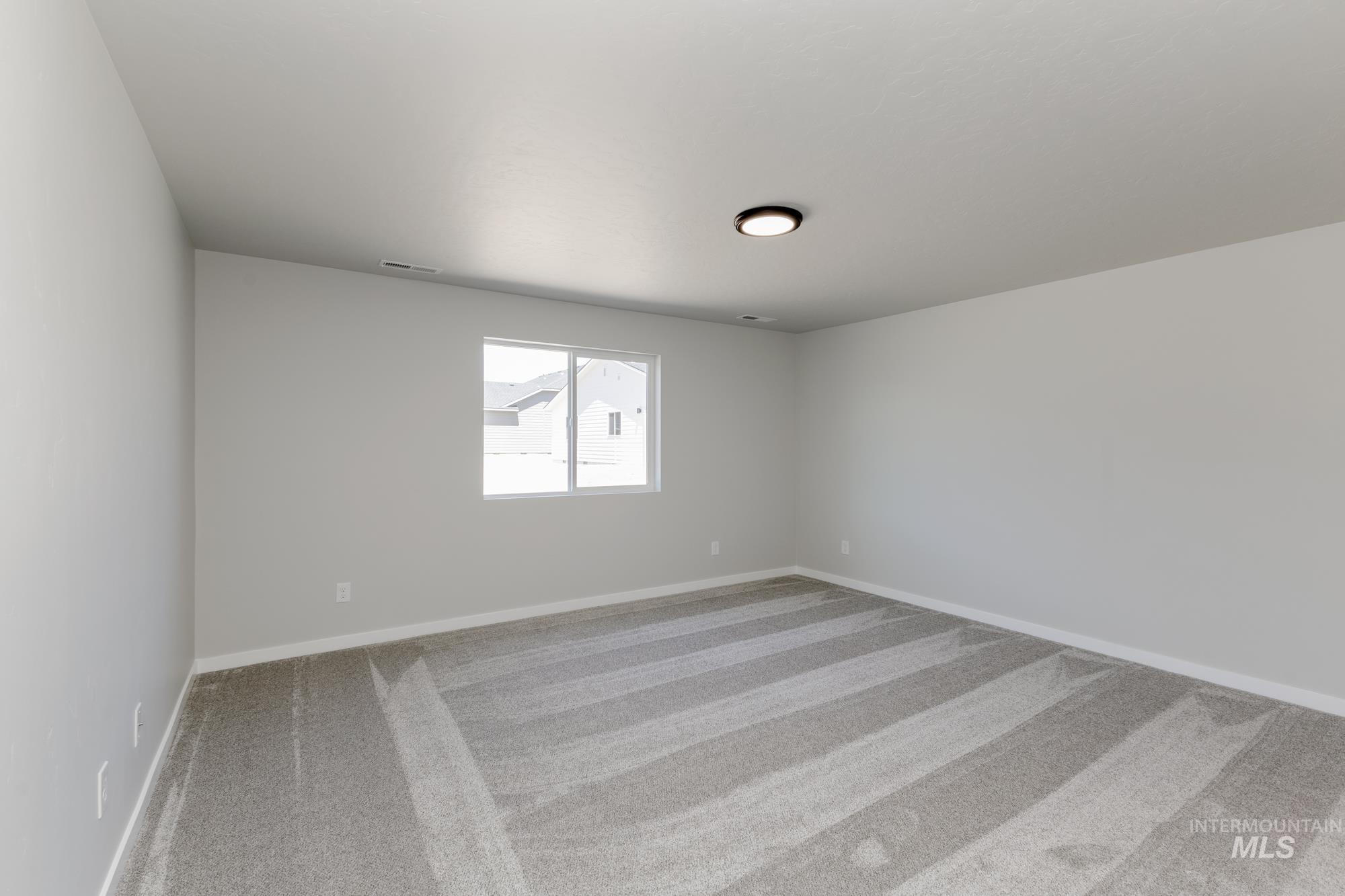 Carpeted empty room with baseboards