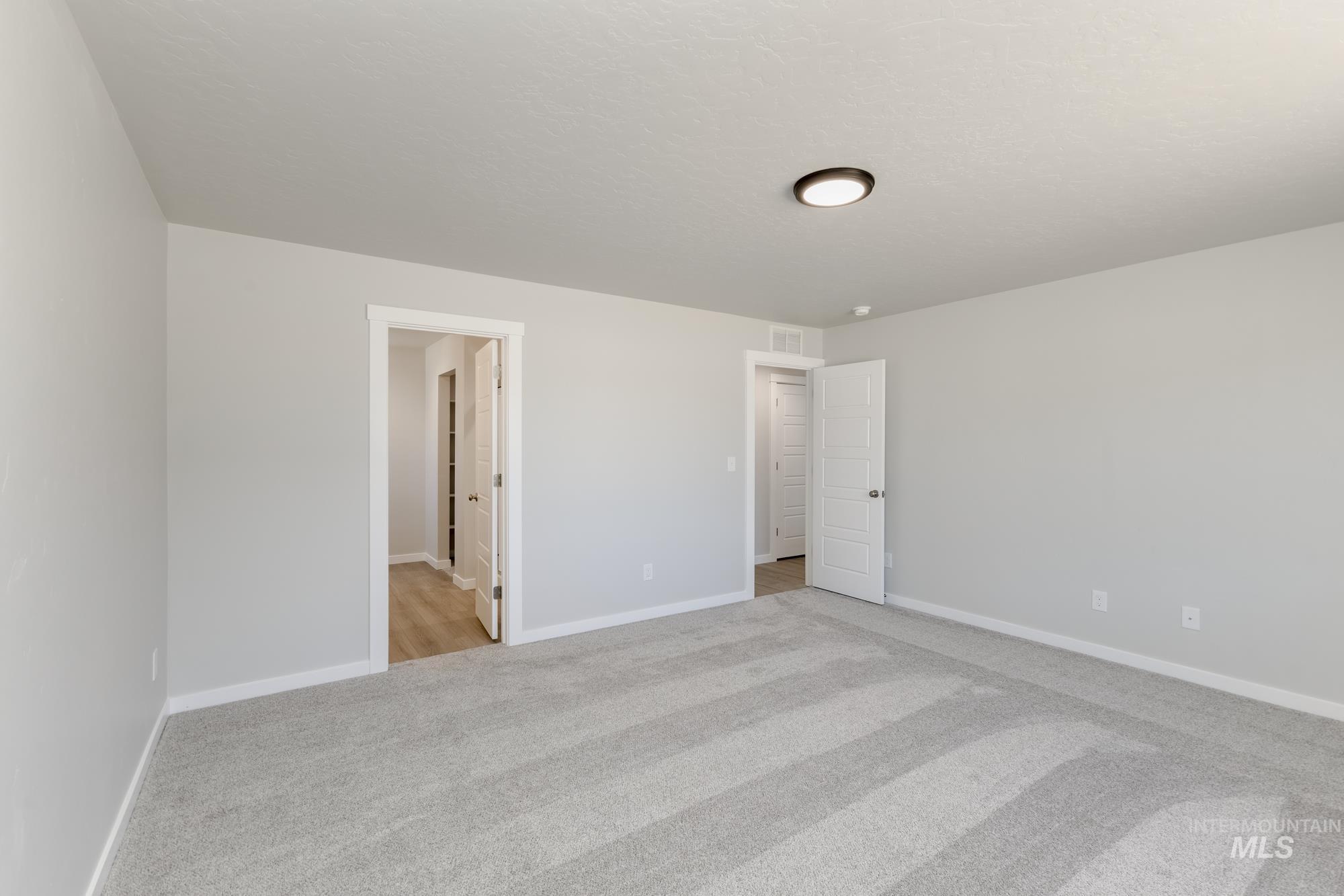 Unfurnished bedroom featuring light colored carpet and baseboards