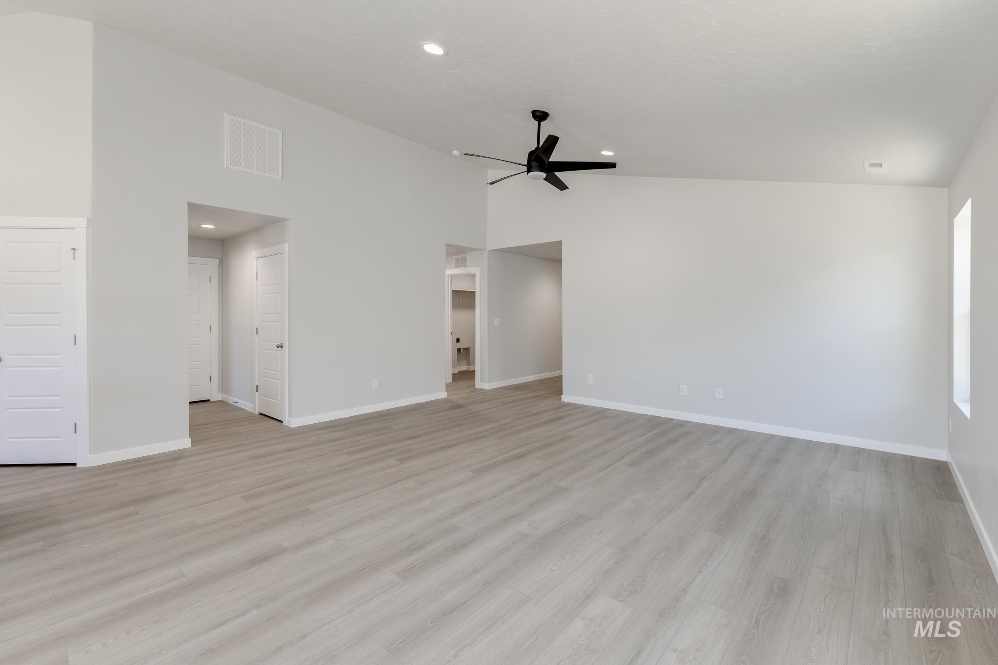 Unfurnished living room with light wood-style floors, high vaulted ceiling, recessed lighting, and ceiling fan