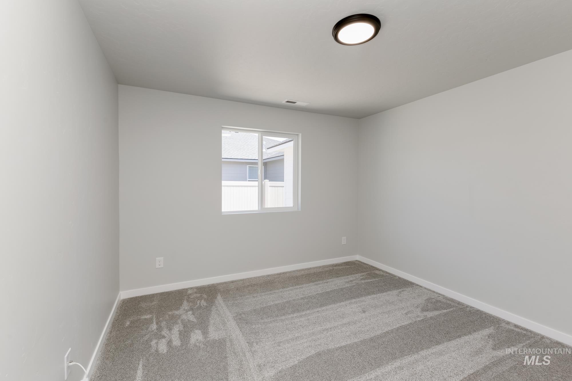Empty room with carpet and baseboards