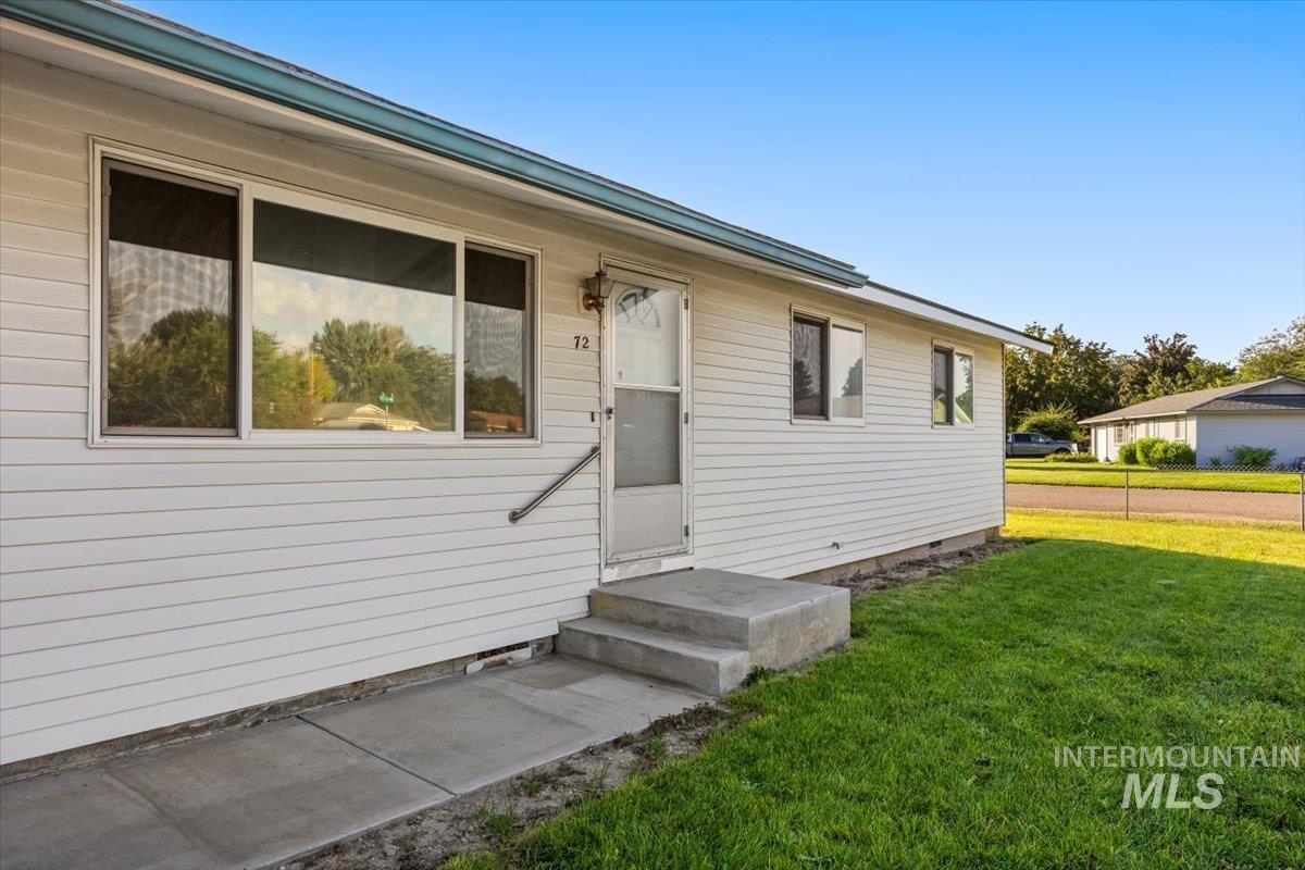 View of exterior entry with a yard
