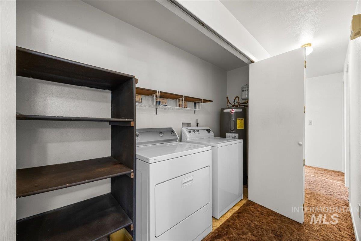 Laundry room with washer and clothes dryer and water heater
