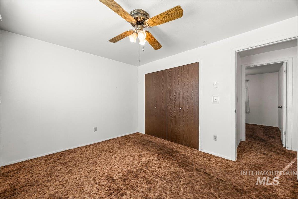 Unfurnished bedroom featuring carpet, a closet, and a ceiling fan
