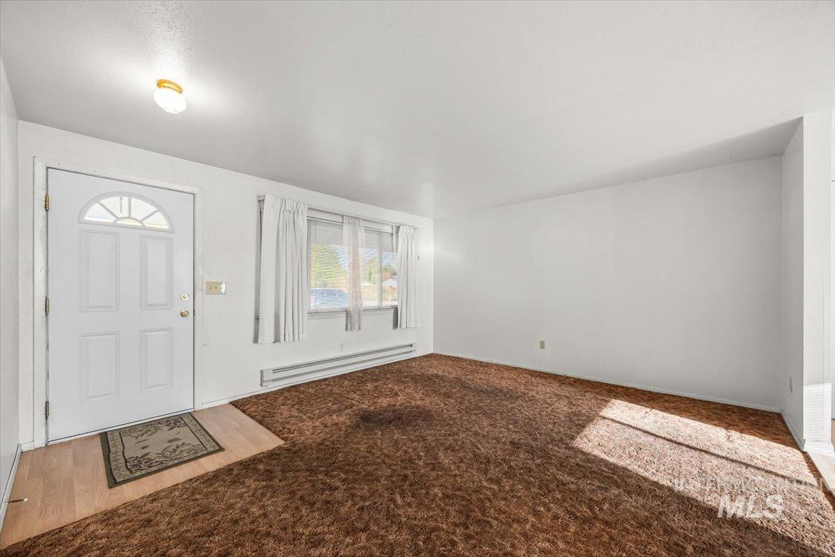 Entryway featuring a baseboard radiator and carpet floors