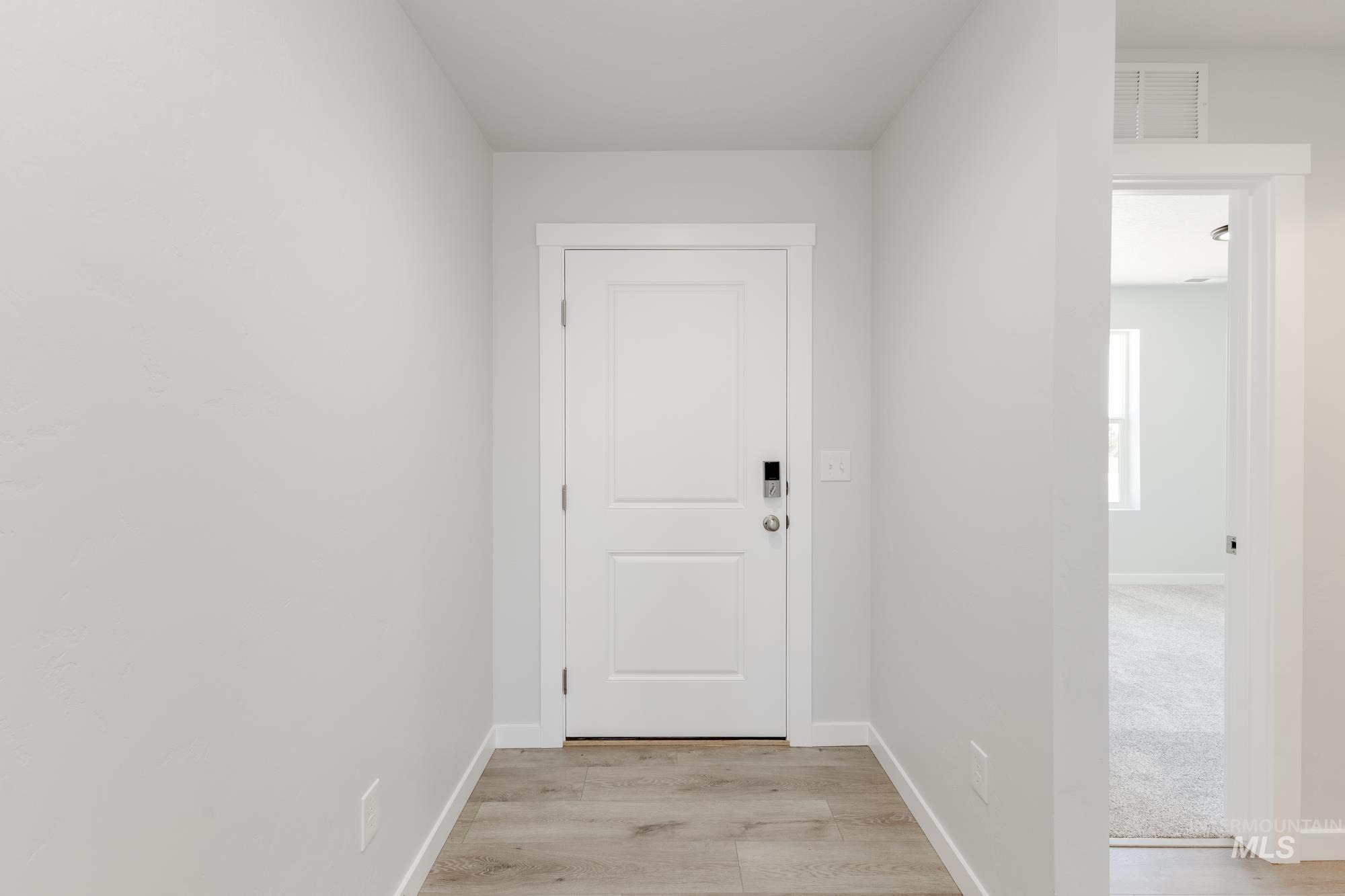 Doorway to outside with baseboards and wood finished floors