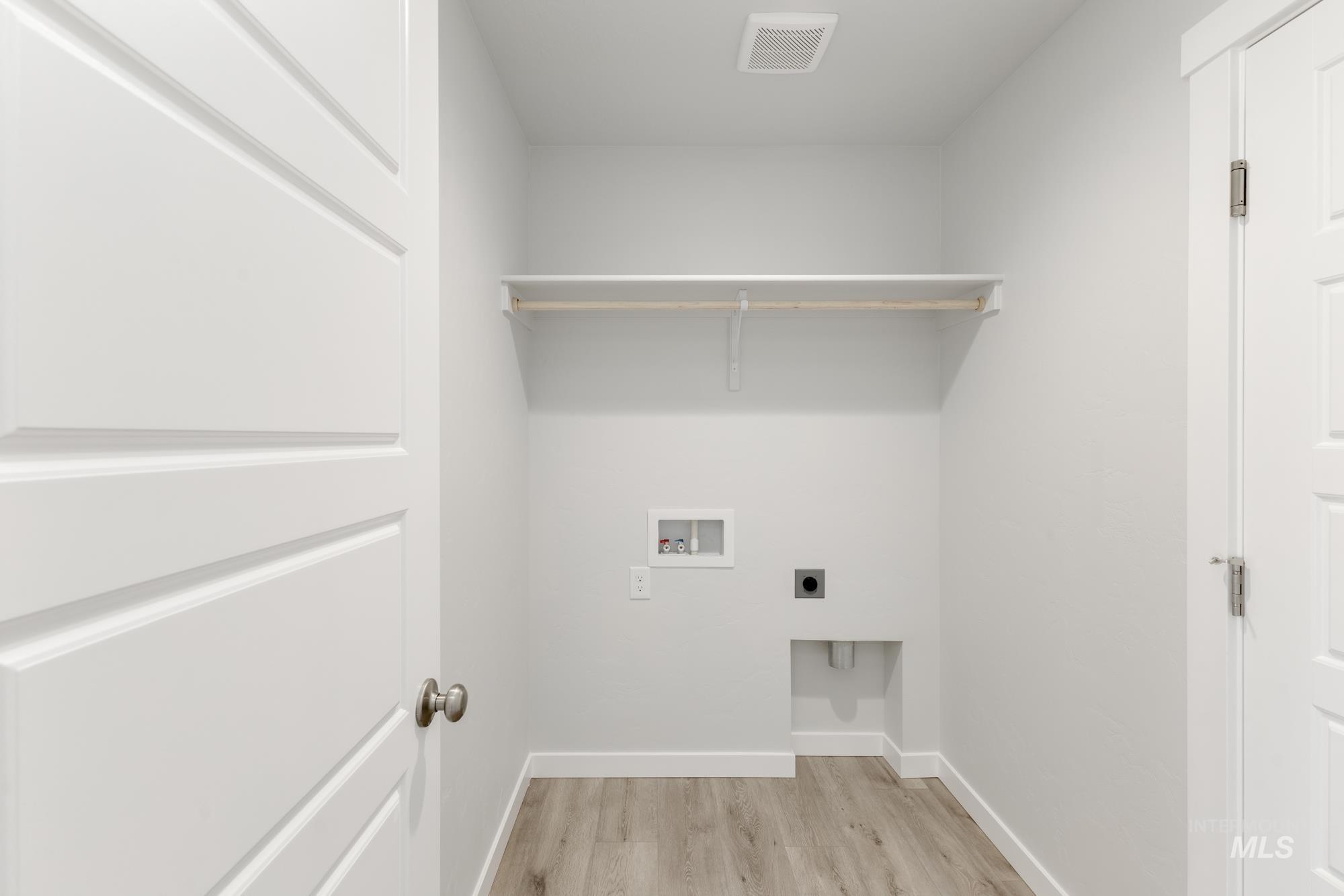 Washroom featuring light wood finished floors, hookup for a washing machine, and hookup for an electric dryer