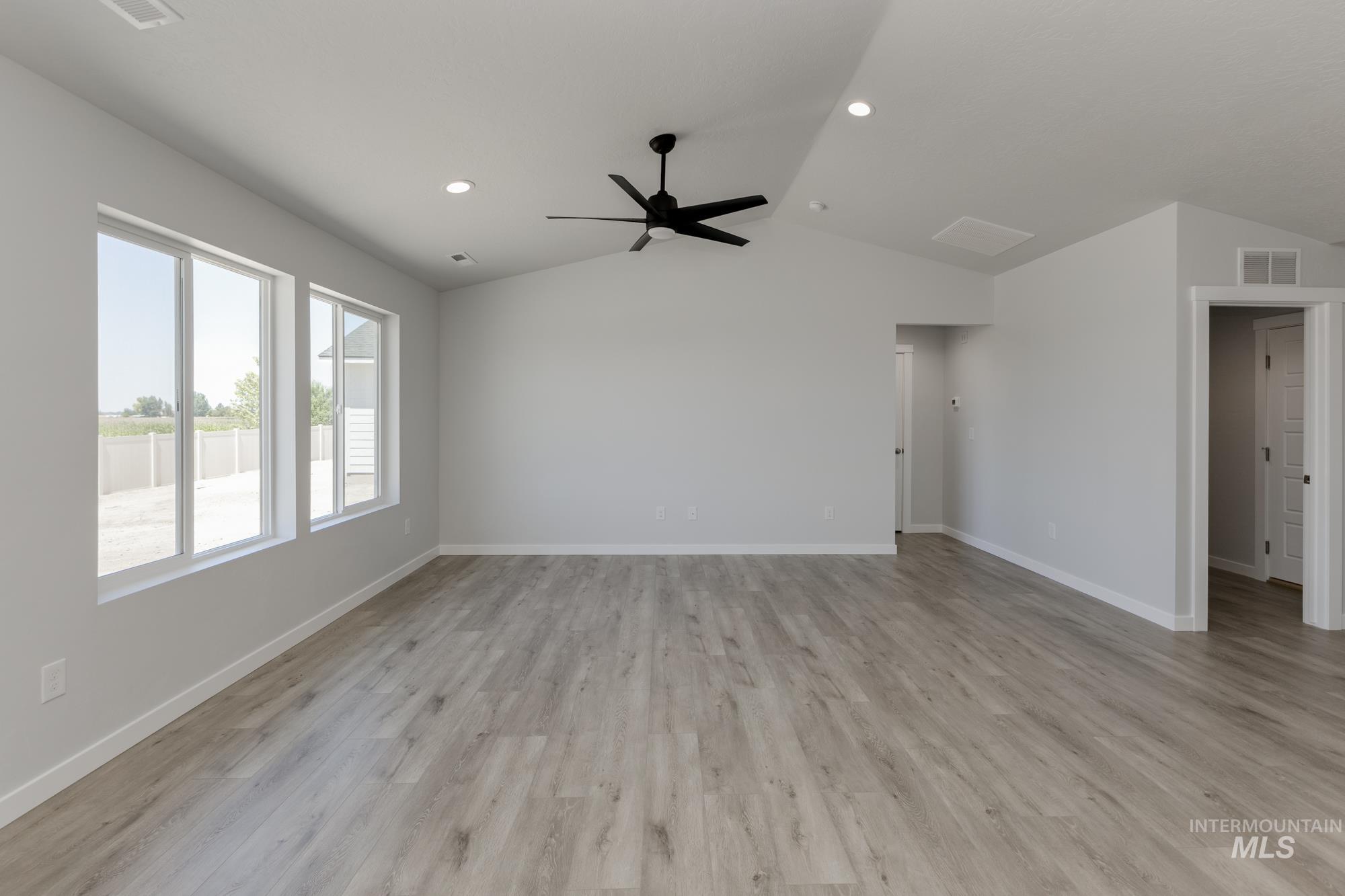 Unfurnished living room featuring vaulted ceiling, light wood-type flooring, recessed lighting, and a ceiling fan