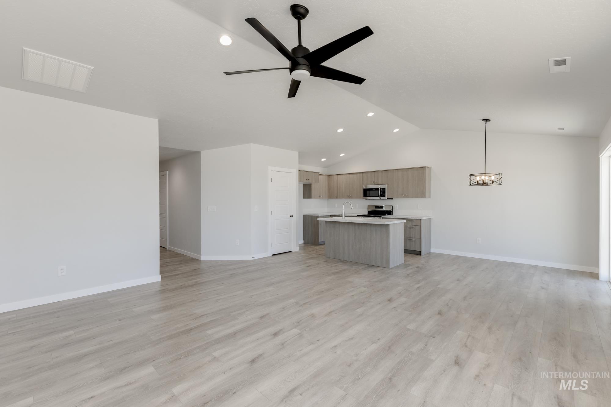Unfurnished living room featuring light wood-type flooring, ceiling fan, recessed lighting, and high vaulted ceiling
