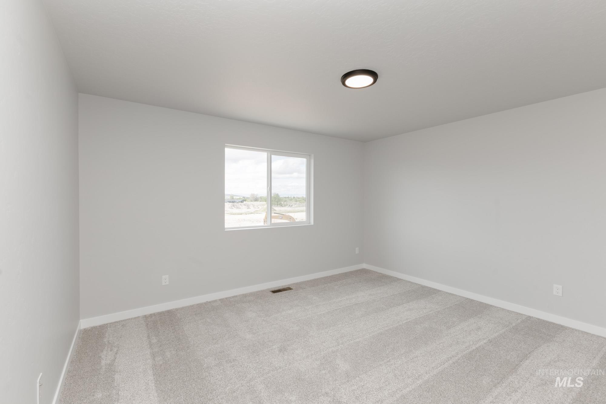 Carpeted empty room featuring baseboards