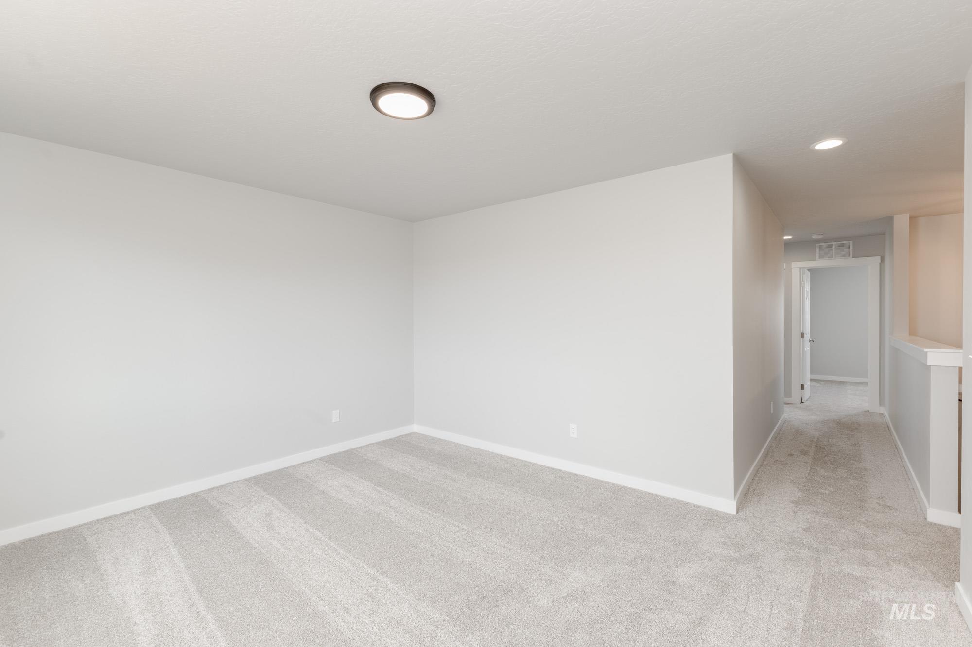 Spare room featuring light colored carpet and recessed lighting