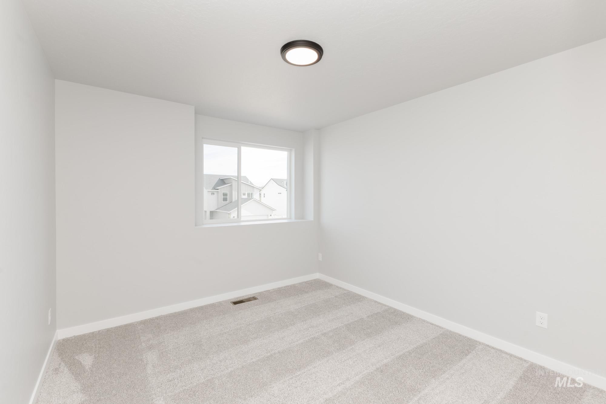 Carpeted spare room with baseboards